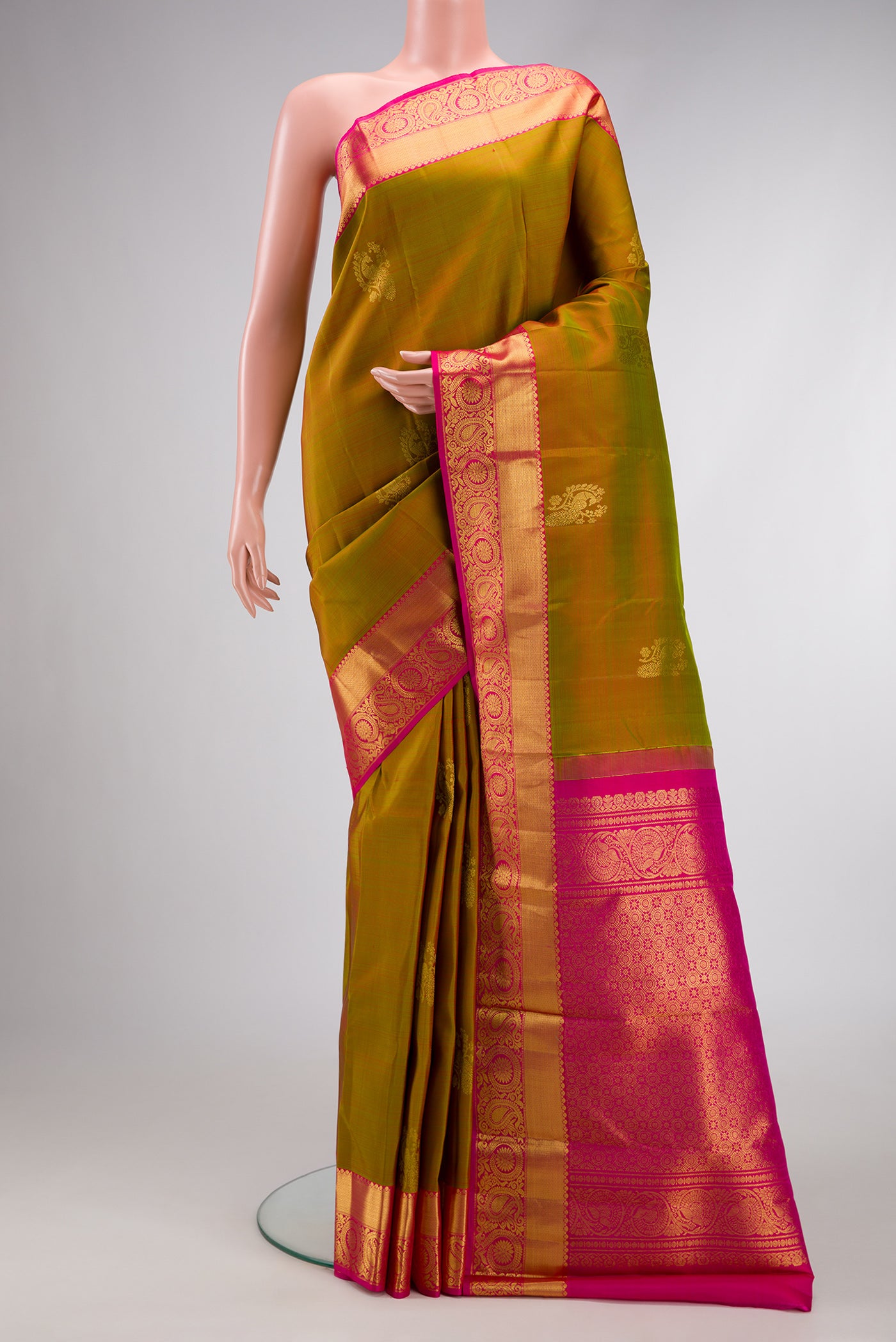 Mehandi Green Dual Tone Kanjivaram Silk Saree with Zari Butta on the body and Zari Border.  displayed on a mannequin