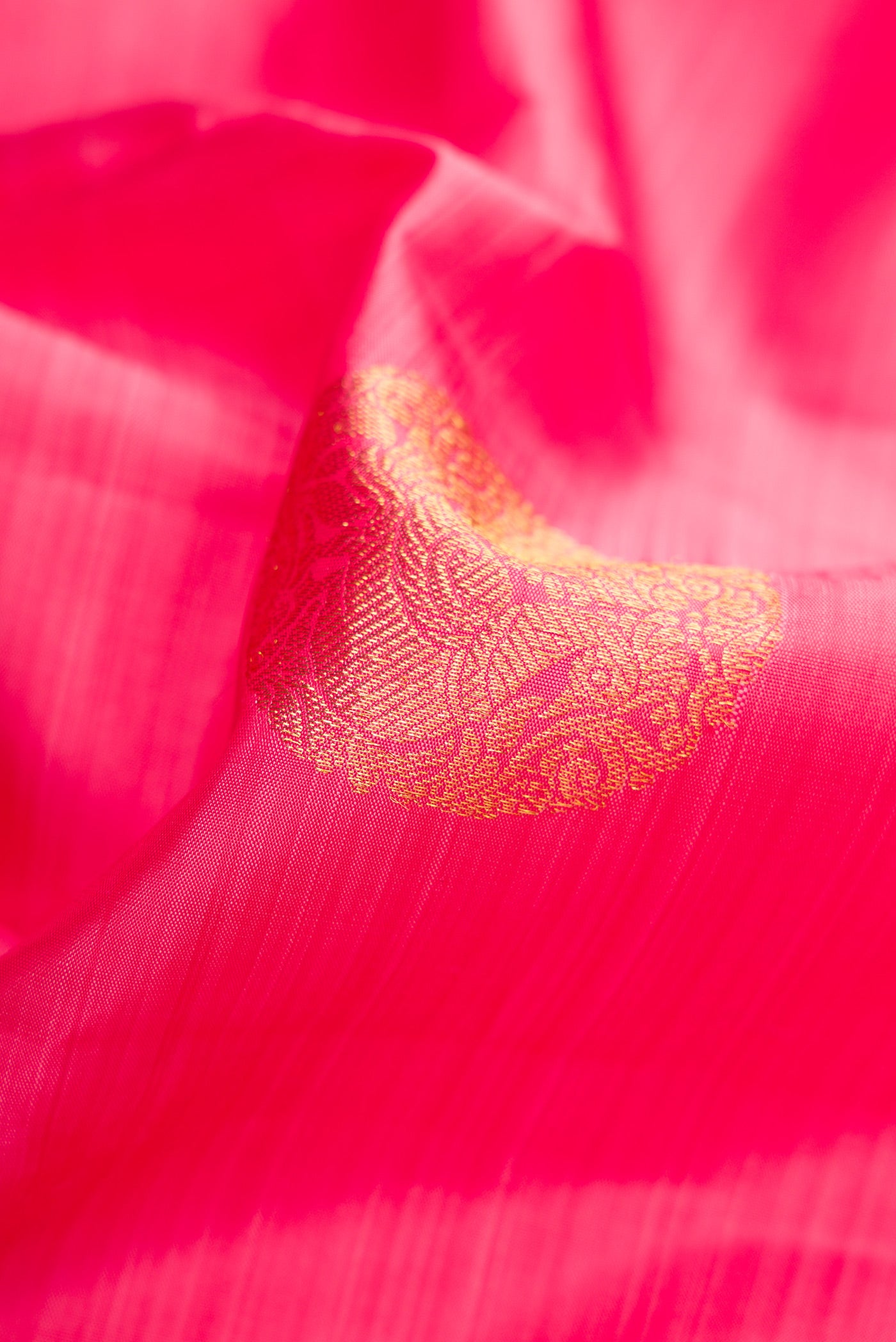 Close up of Pink Dual Tone Kanjivaram Silk Saree with Zari Butta on the body and Zari Border.  displaying folds
