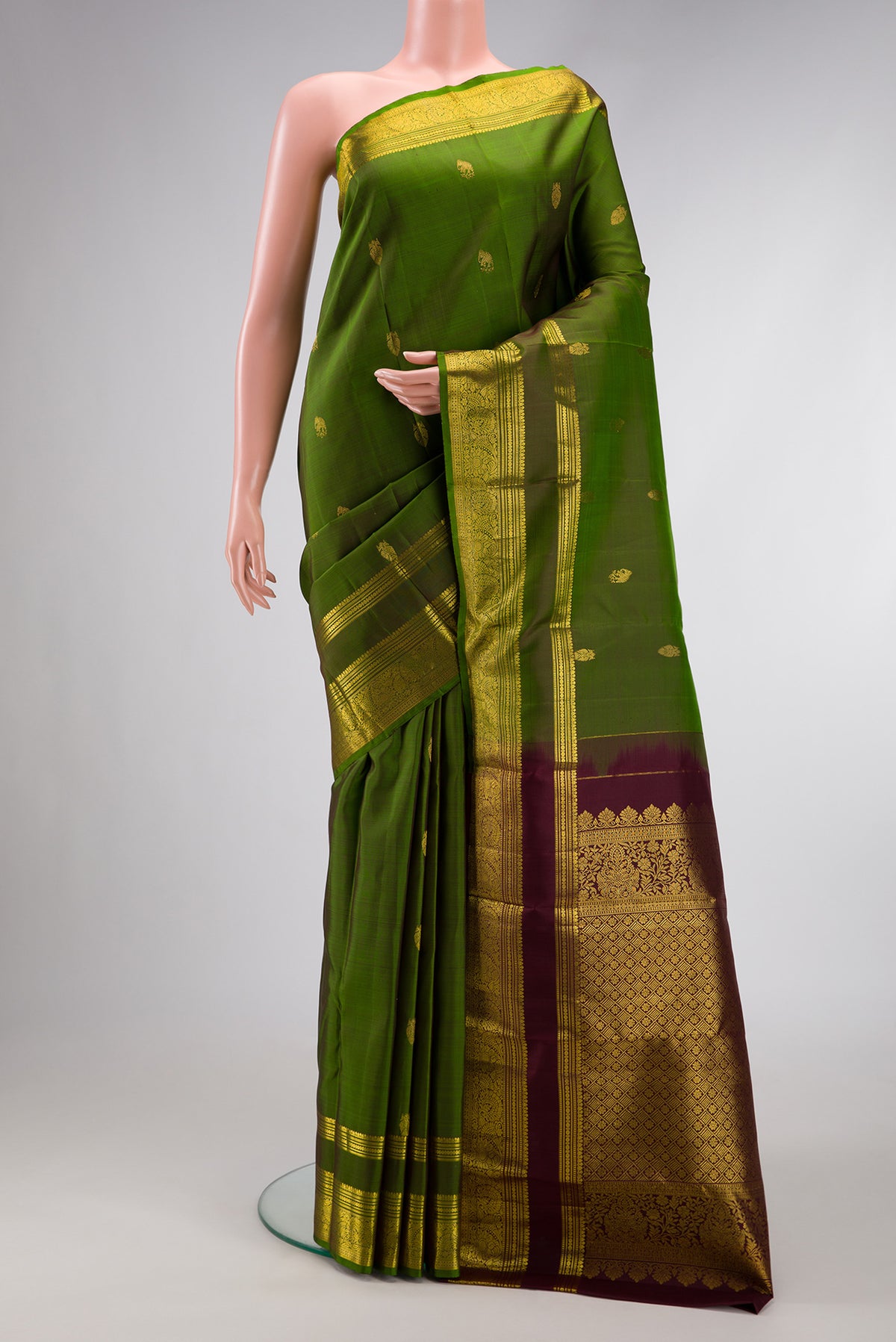 Mehandi Green Dual Tone Kanjivaram Silk Saree with Zari Butta on the body and Zari Border.  displayed on a mannequin