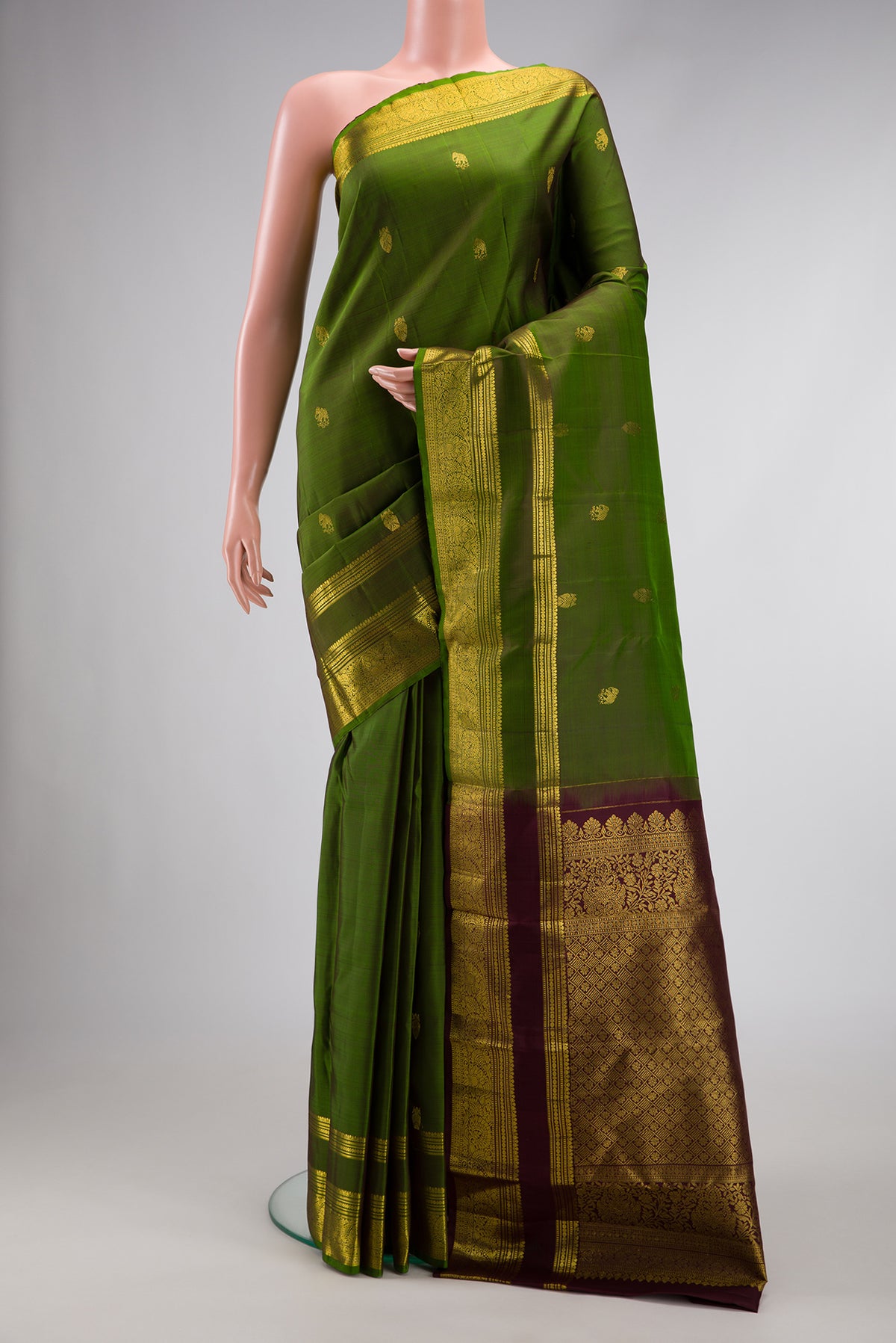 Green Dual Tone Kanjivaram Silk Saree with Zari Butta on the body and Zari Border.  displayed on a mannequin