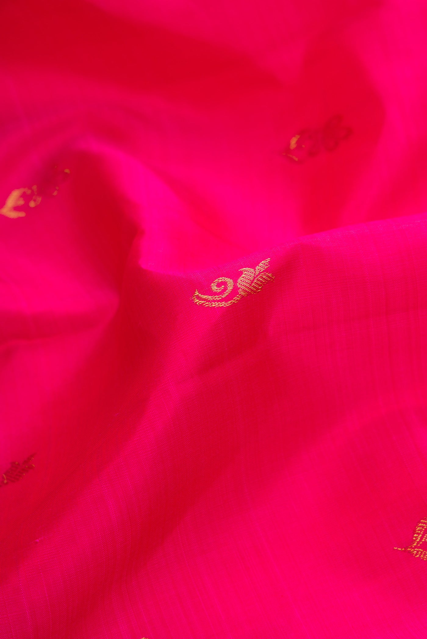 Close up of Pink Dual Tone Kanjivaram Silk Saree with Zari Butta on the body and Zari Border.  displaying folds