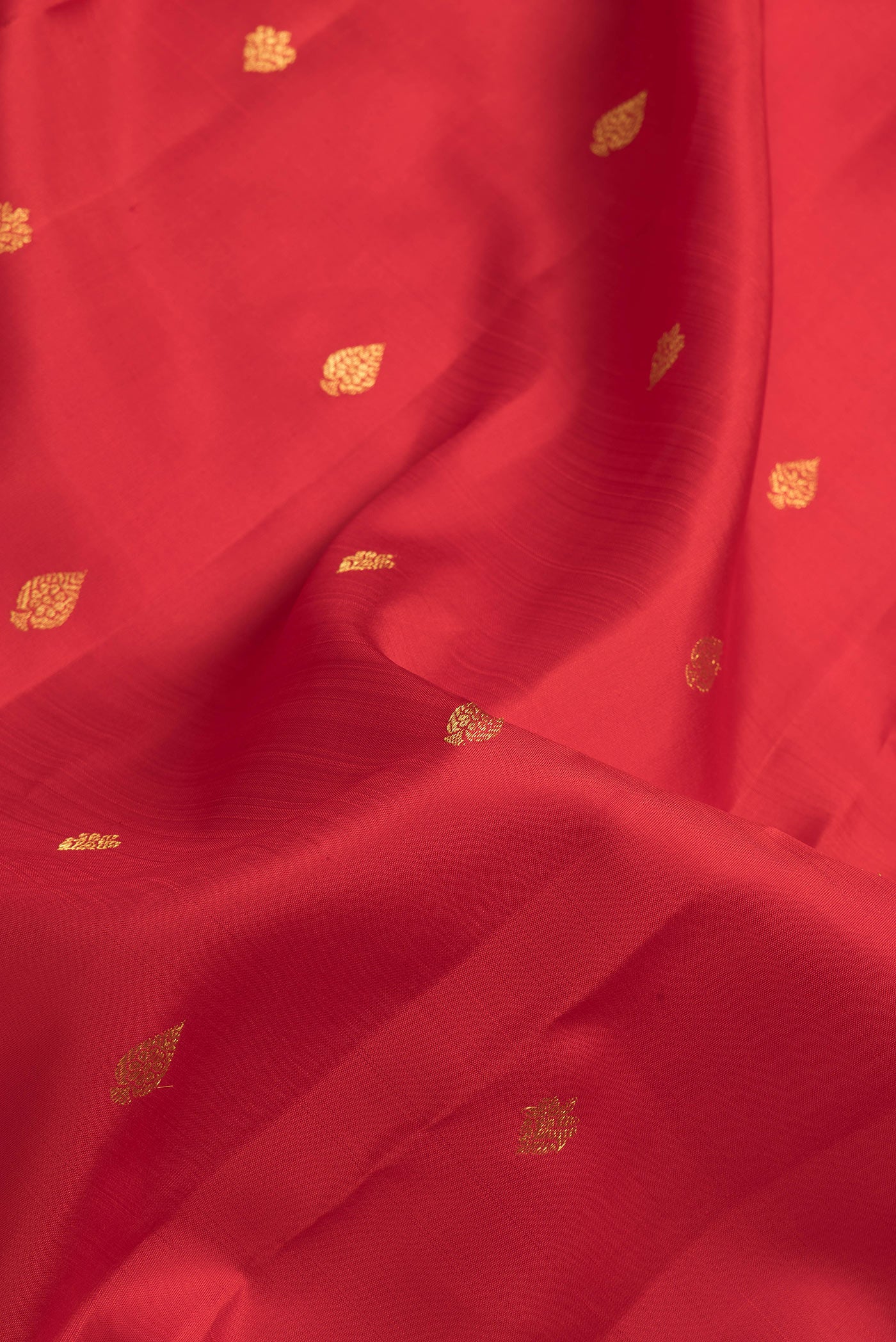 Close up of Red Dual Tone Kanjivaram Silk Saree with Zari Butta on the body and Zari Border.  displaying folds