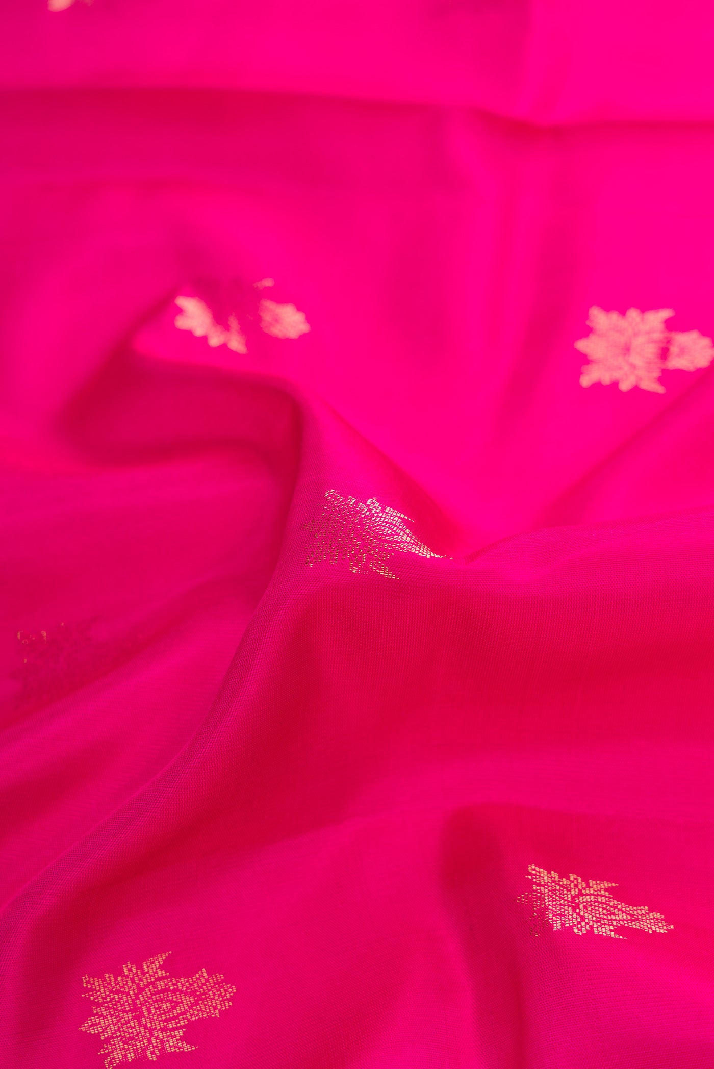 Close up of Pink Dual Tone Soft Silk Saree with Zari Butta on the body and Zari Border.  displaying folds