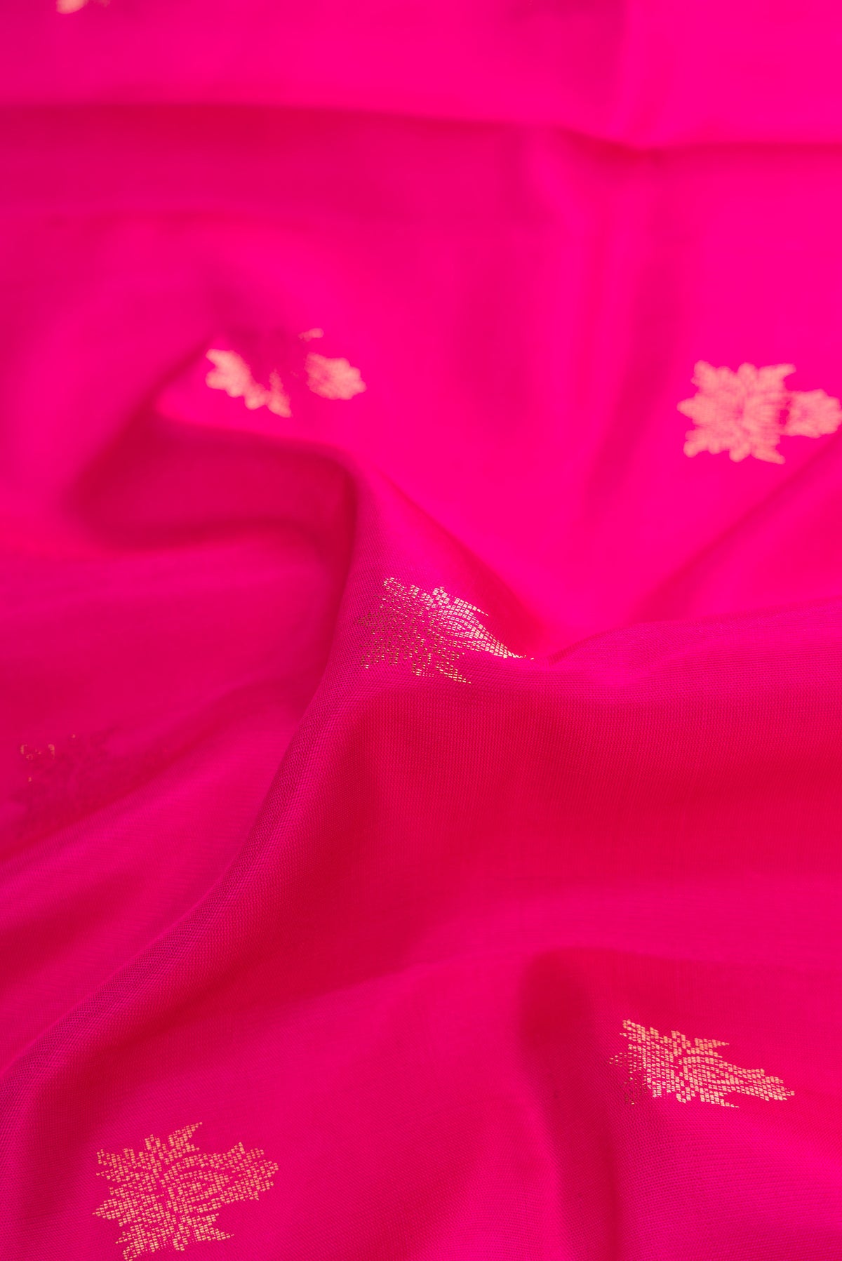 Close up of Pink Dual Tone Soft Silk Saree with Zari Butta on the body and Zari Border.  displaying folds