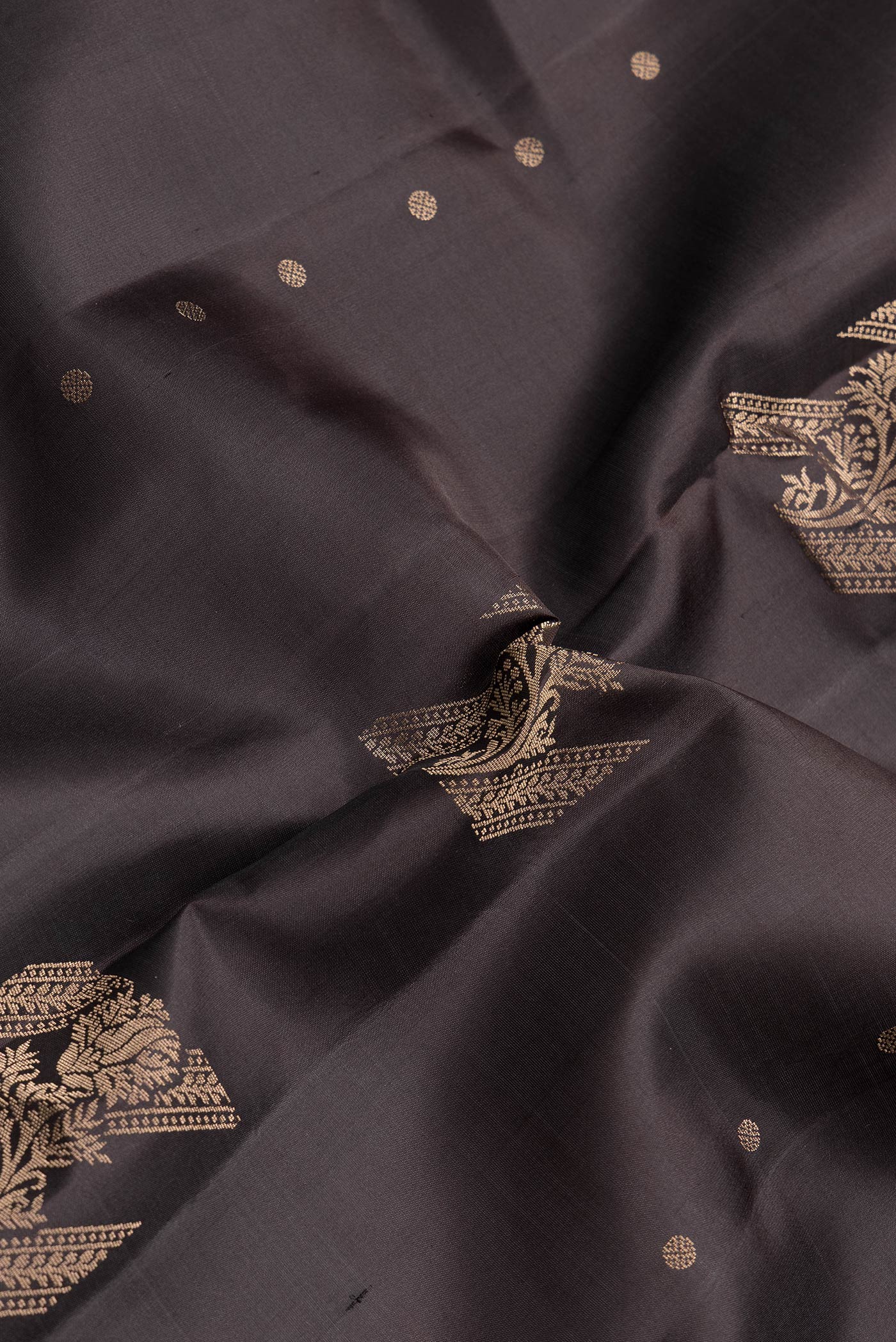 Close up of Coffee Brown Dual Tone Soft Silk Saree with Zari Butta on the body and Without Border.  displaying folds