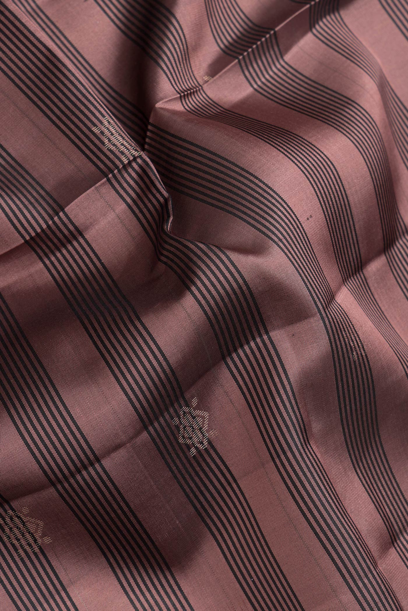 Close up of Rose Gold Dual Tone Soft Silk Saree with Zari Butta on the body and Zari Border.  displaying folds