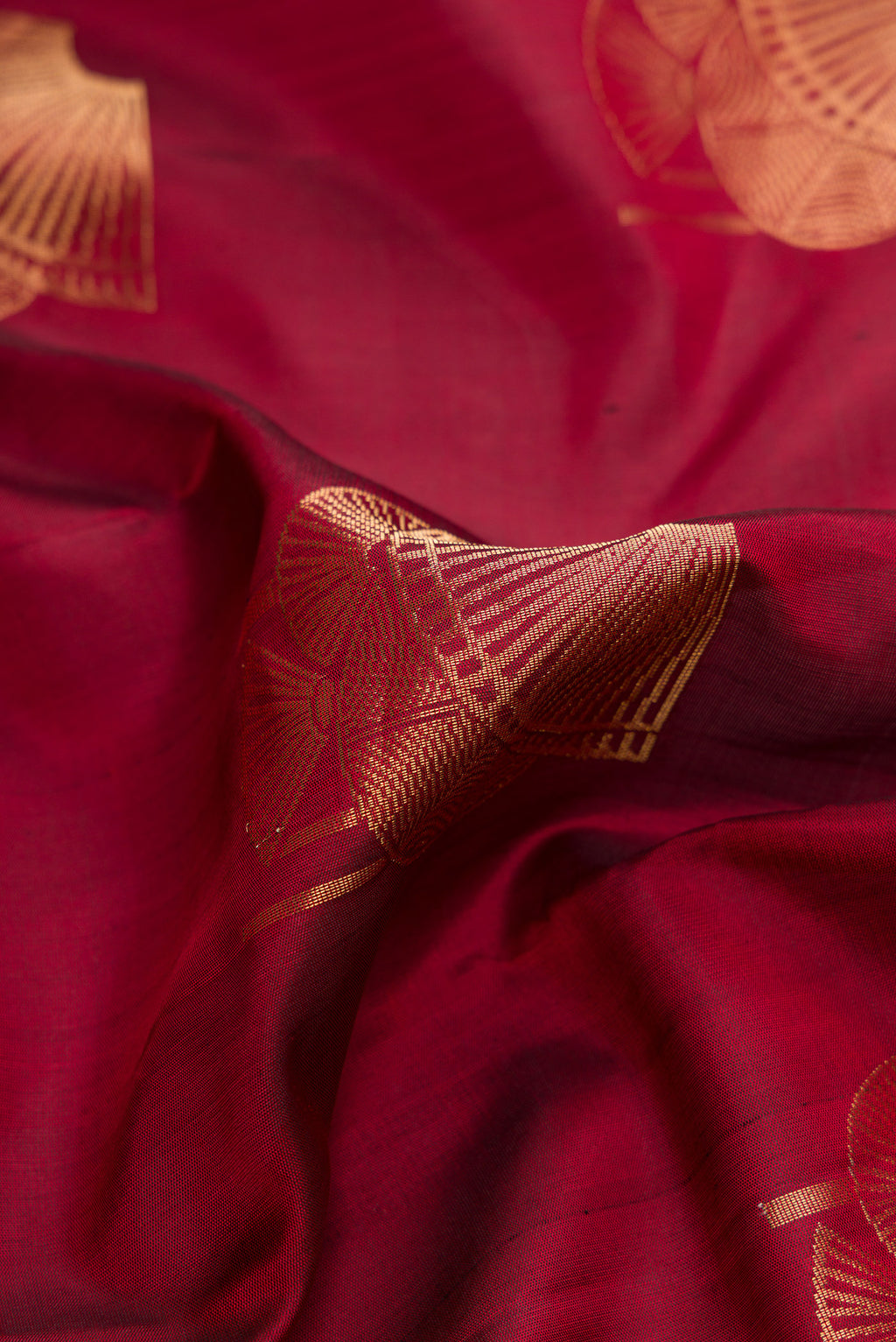 Close up of Maroon Dual Tone Soft Silk Saree with Zari Butta on the body and Without Border.  displaying folds