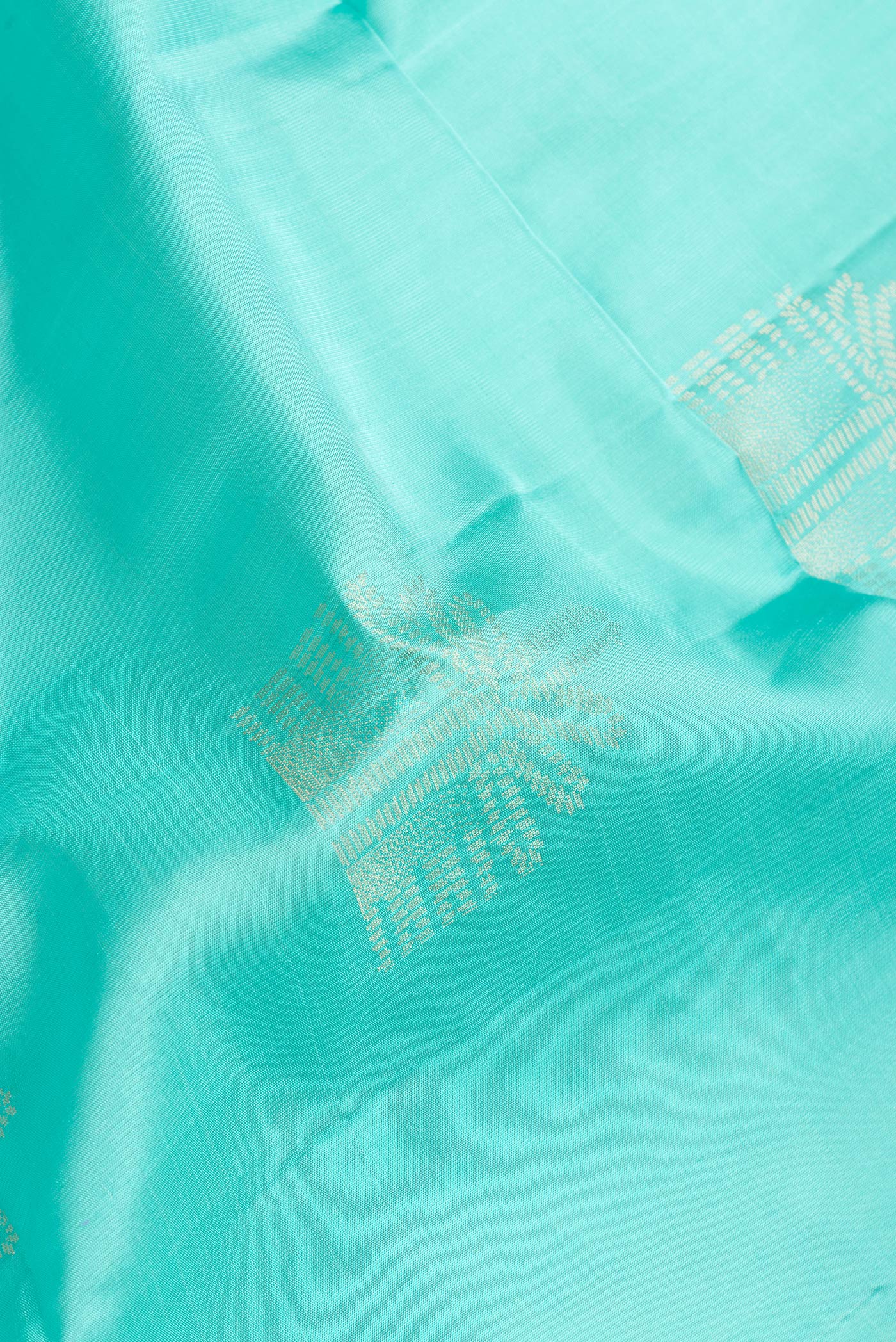 Close up of Sky Blue Dual Tone Soft Silk Saree with Zari Butta on the body and Without Border.  displaying folds