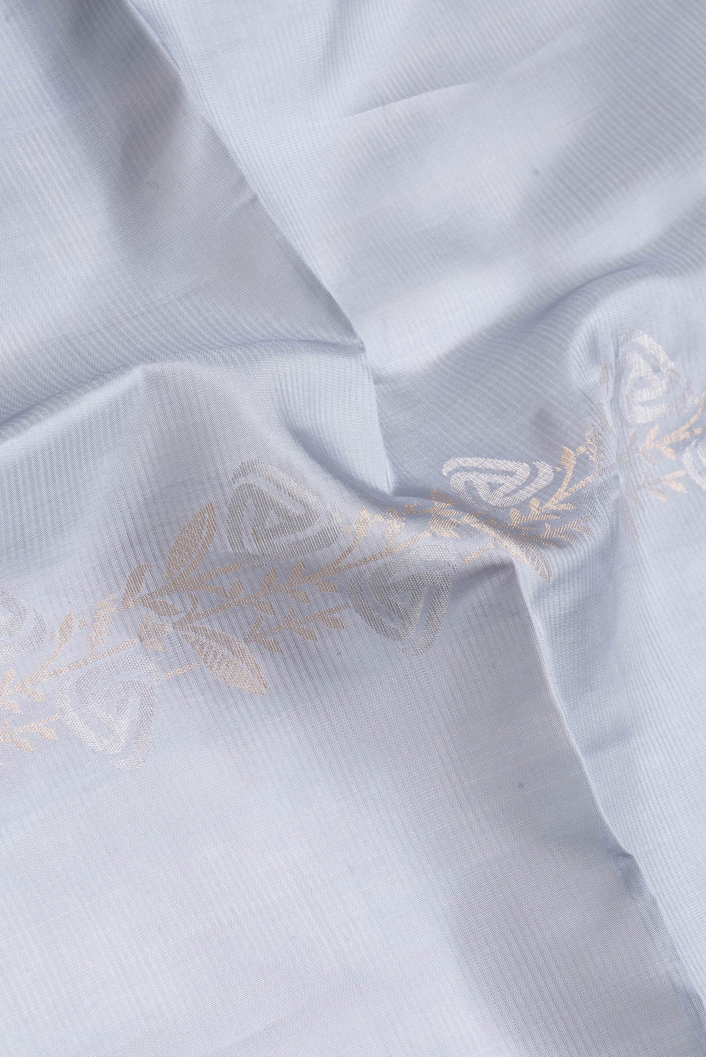 Close up of Grey Dual Tone Soft Silk Saree with Zari Butta on the body and Zari Border.  displaying folds