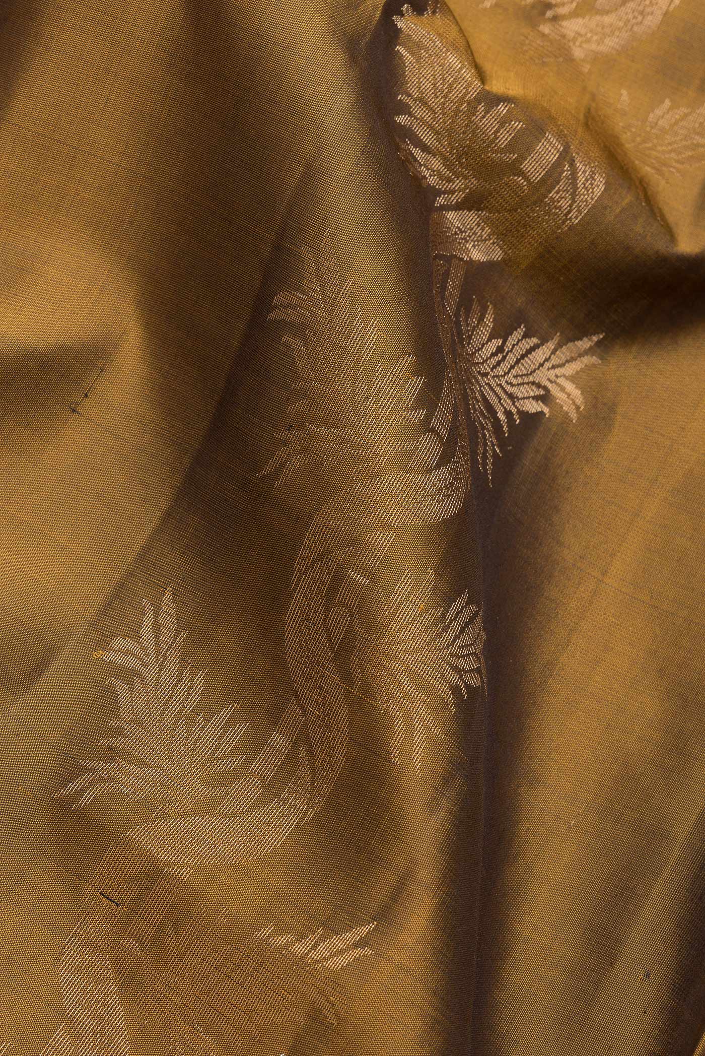 Close up of Gold Dual Tone Soft Silk Saree with Zari Butta on the body and Zari Border.  displaying folds