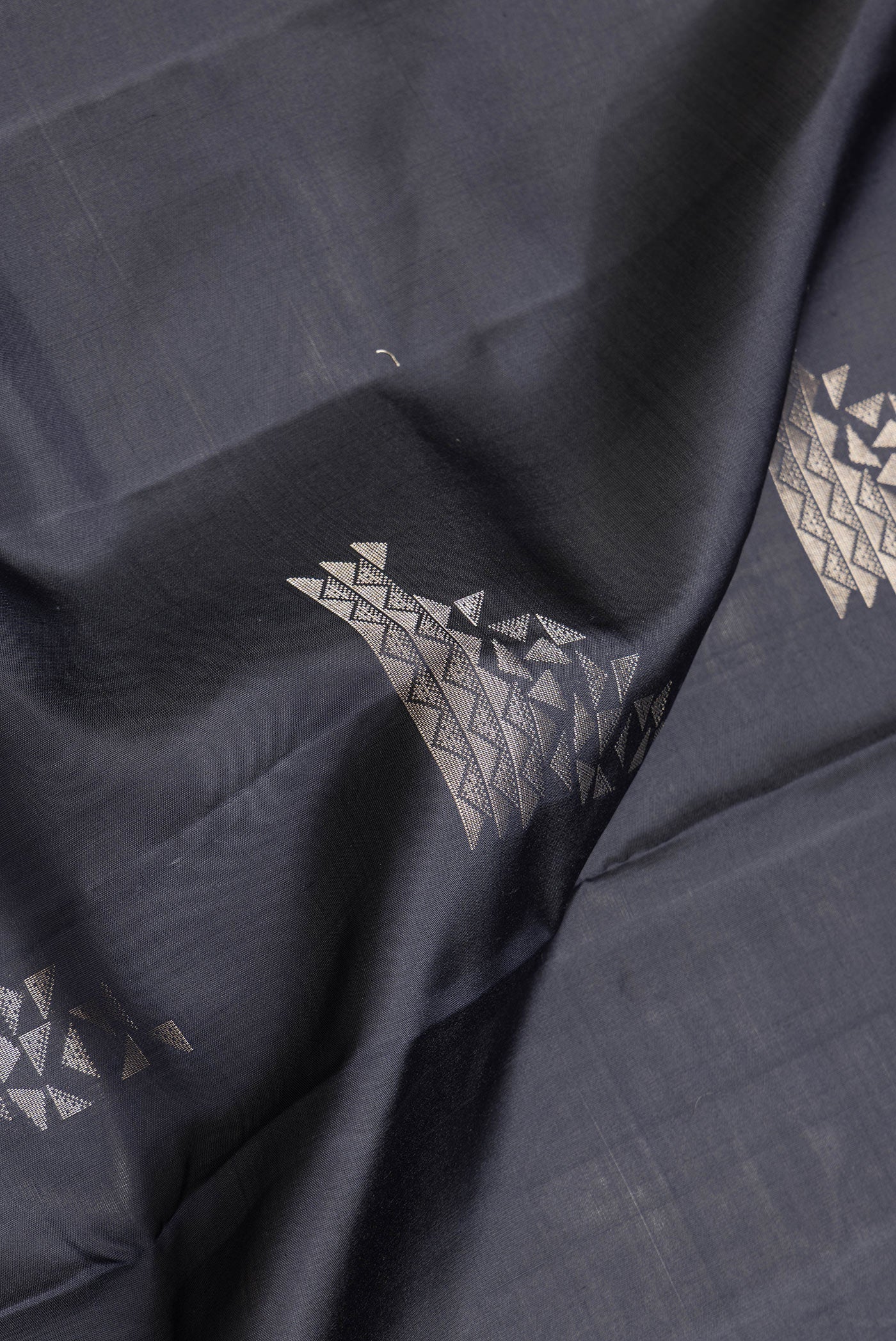 Close up of Black Dual Tone Soft Silk Saree with Zari Butta on the body and Zari Border.  displaying folds