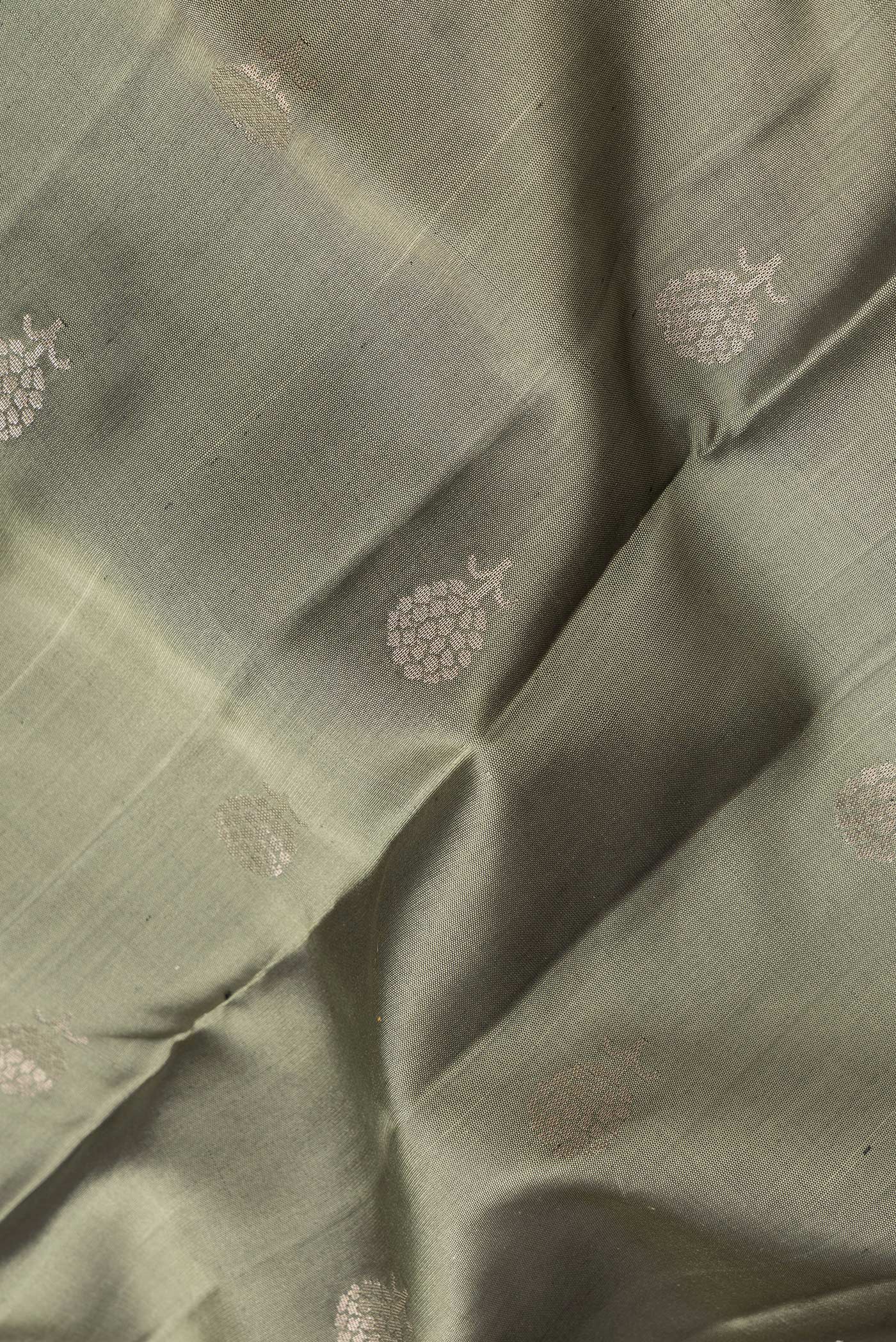 Close up of Mehandi Green Dual Tone Soft Silk Saree with Zari Butta on the body and Zari Border.  displaying folds