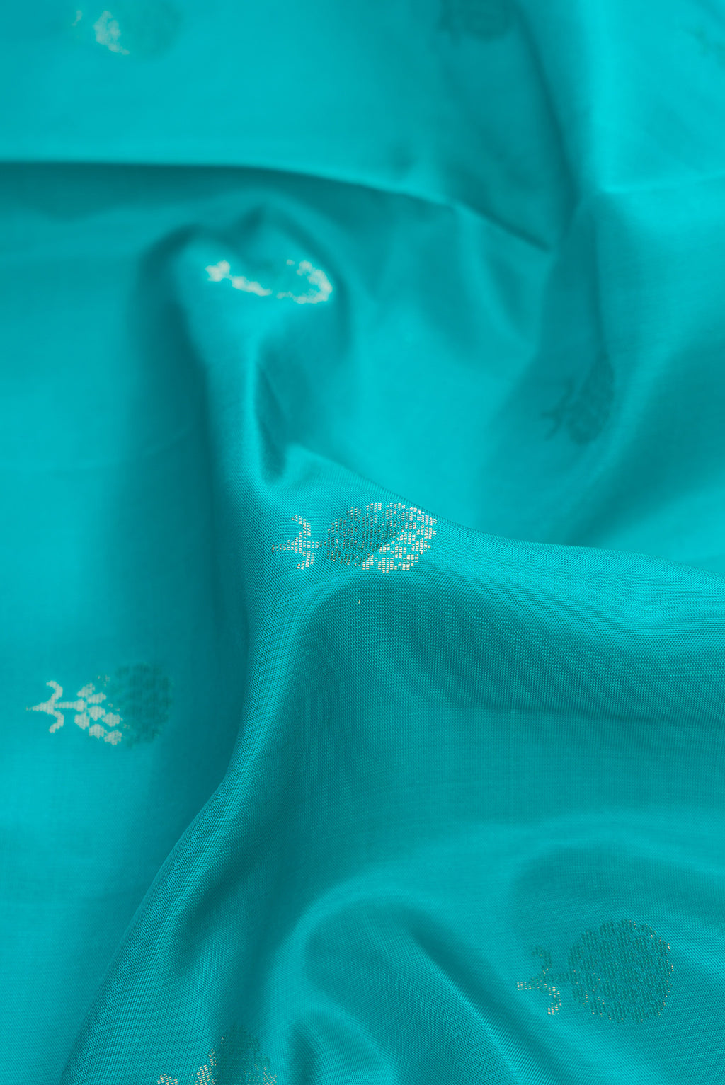Close up of Maya Blue Dual Tone Soft Silk Saree with Zari Butta on the body and Zari Border.  displaying folds