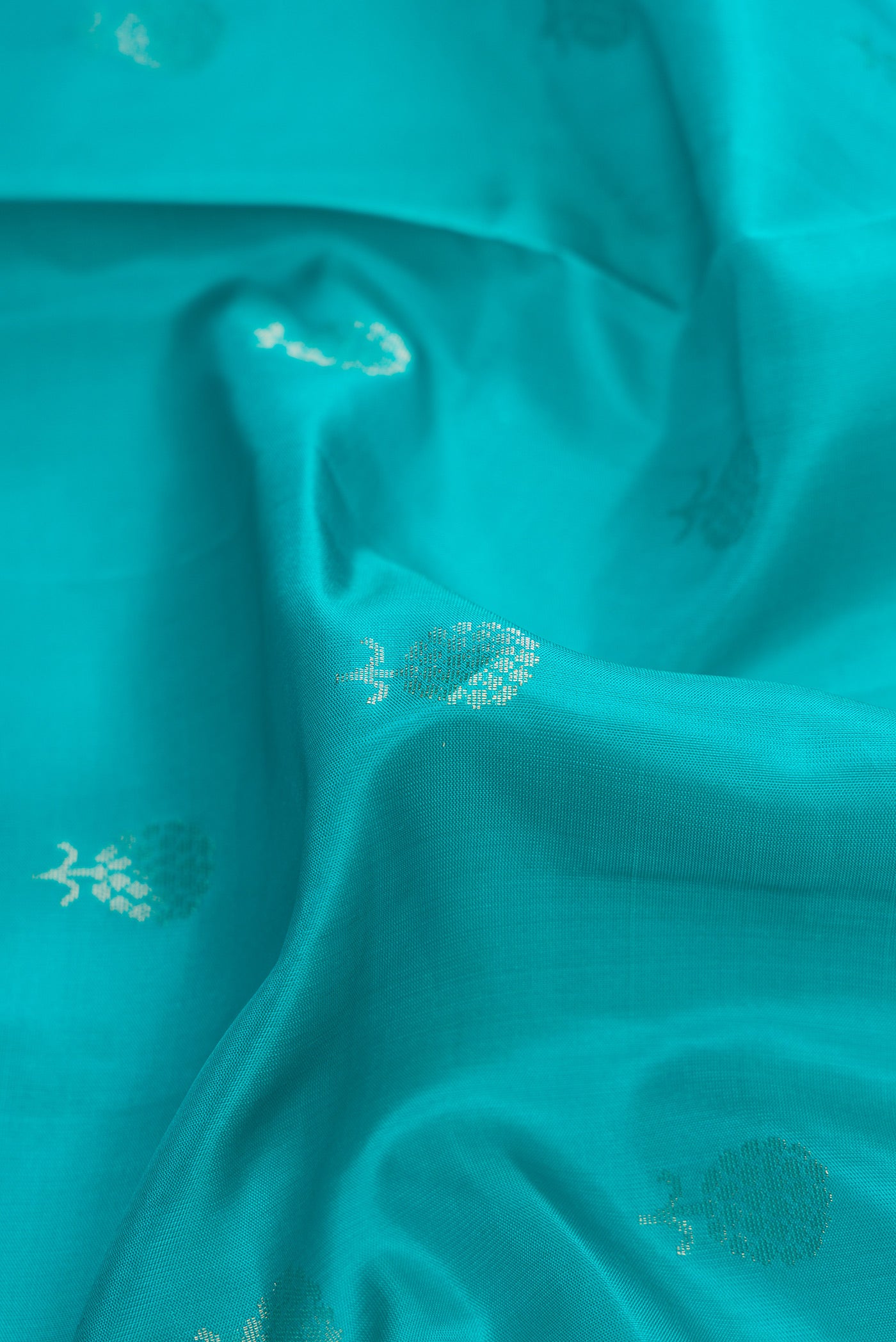 Close up of Maya Blue Dual Tone Soft Silk Saree with Zari Butta on the body and Zari Border.  displaying folds