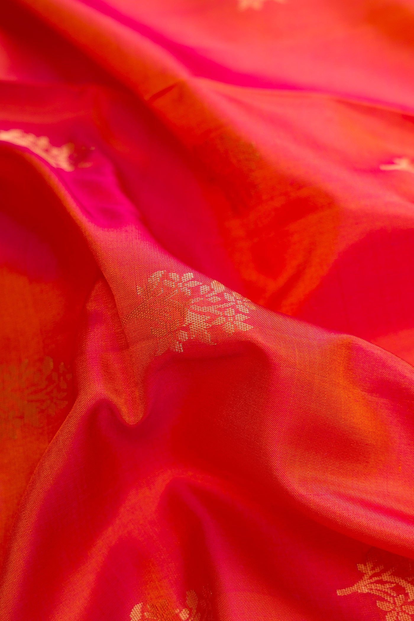 Close up of Brick Orange Dual Tone Soft Silk Saree with Zari Butta on the body and Zari Border.  displaying folds