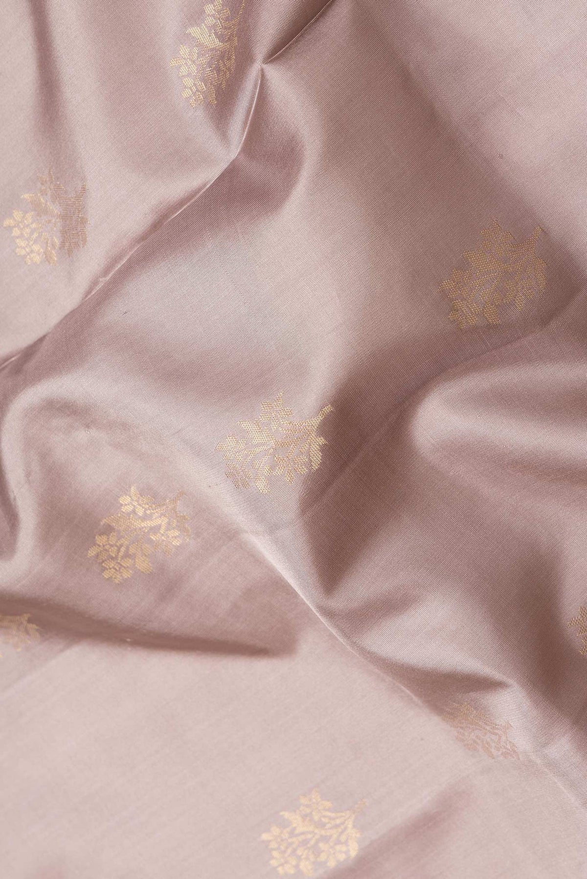 Close up of Beige Dual Tone Soft Silk Saree with Zari Butta on the body and Zari Border.  displaying folds