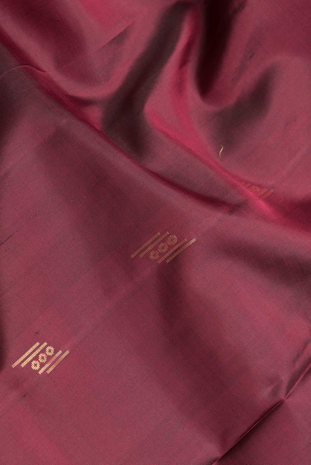 Close up of Maroon Dual Tone Soft Silk Saree with Zari Butta on the body and Zari Border.  displaying folds