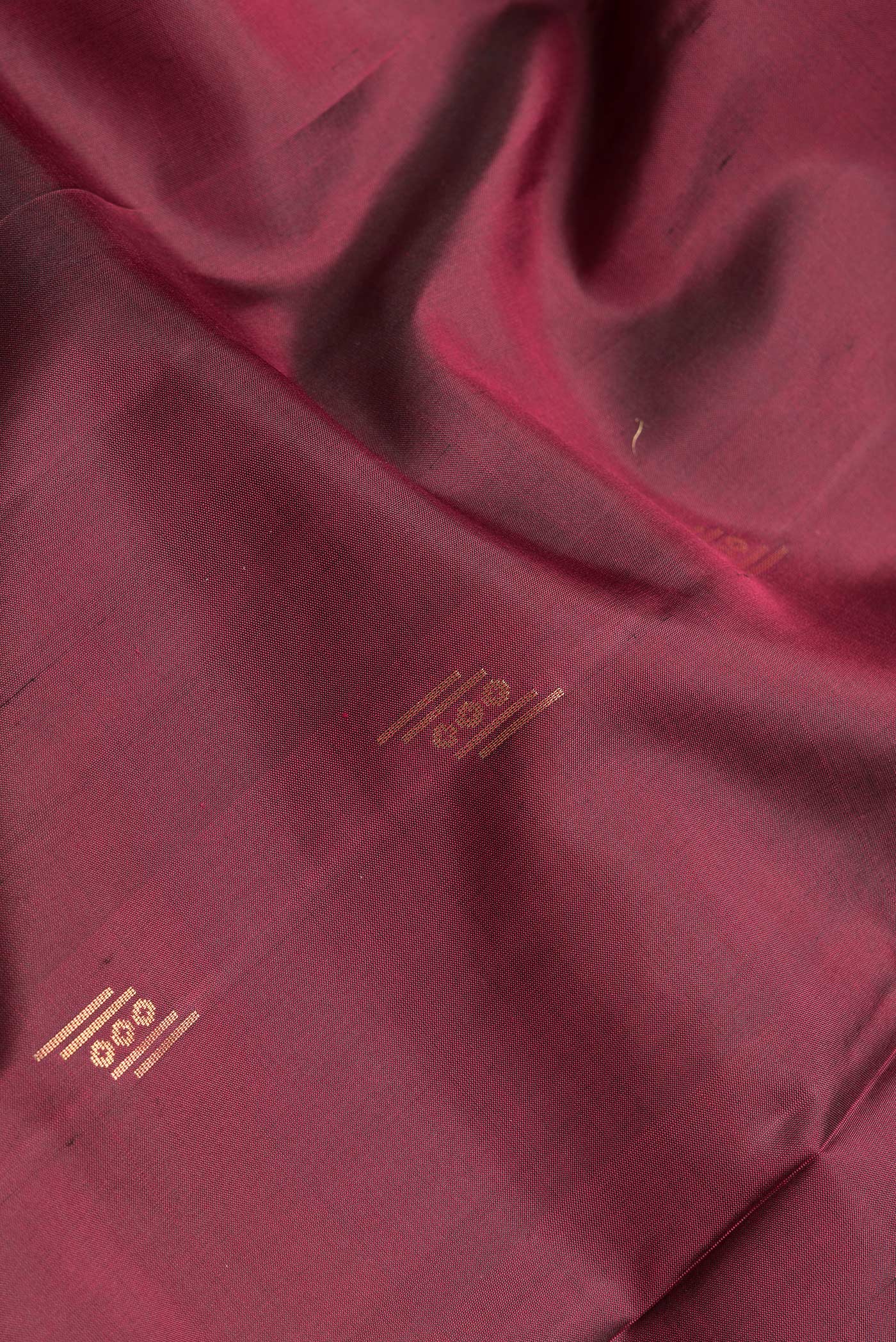 Close up of Maroon Dual Tone Soft Silk Saree with Zari Butta on the body and Zari Border.  displaying folds