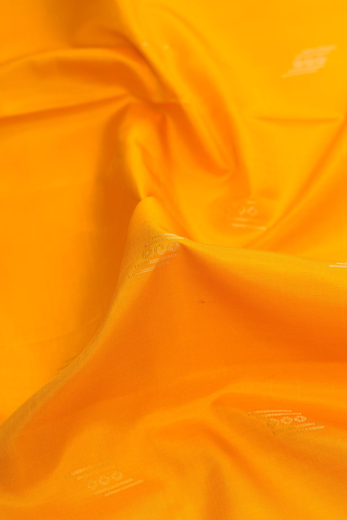Close up of Mustard Dual Tone Soft Silk Saree with Zari Butta on the body and Zari Border.  displaying folds