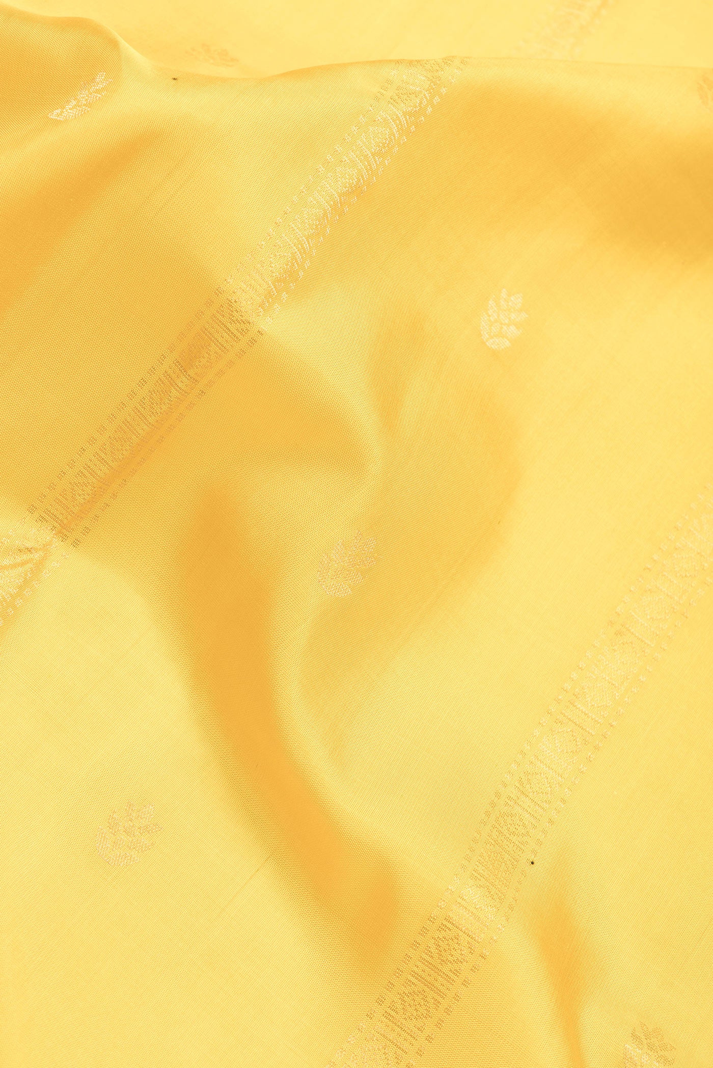 Close up of Yellow Dual Tone Soft Silk Saree with Zari Butta on the body and Zari Border.  displaying folds