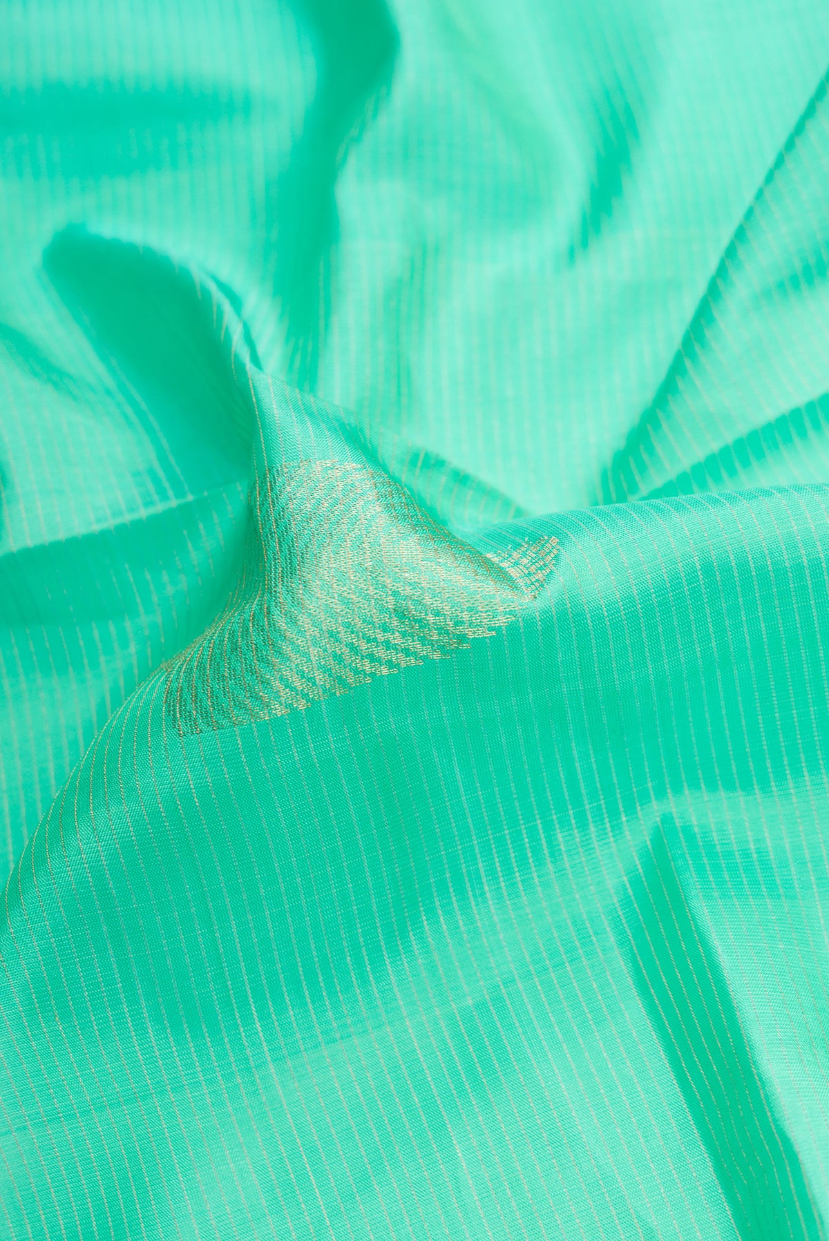 Close up of Sea Green Dual Tone Soft Silk Saree with Zari Butta on the body and Without Border.  displaying folds