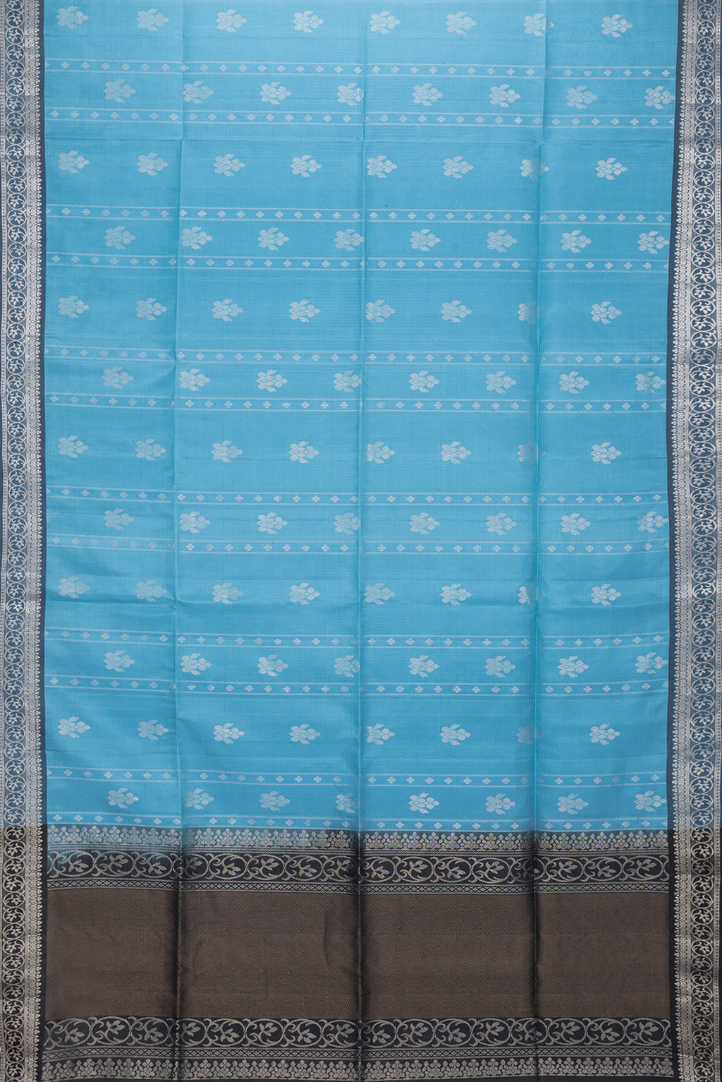 Flat view of Sky Blue Dual Tone Soft Silk Saree with Zari Butta on the body and Zari Border. 
