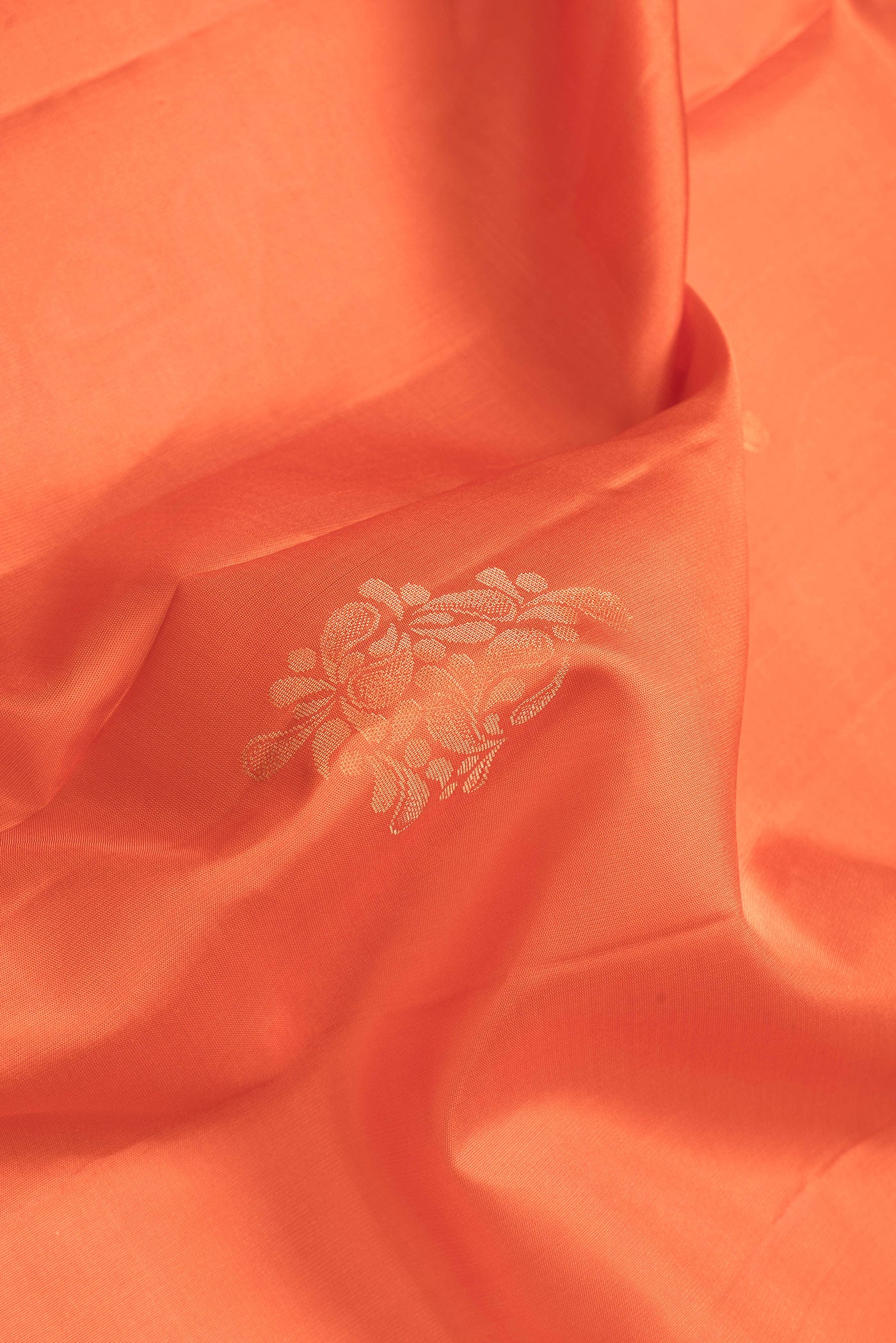 Close up of Orange Dual Tone Soft Silk Saree with Zari Butta on the body and Zari Border.  displaying folds