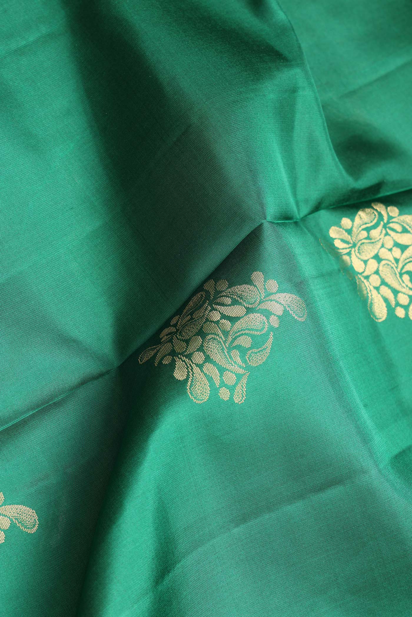 Close up of Bottle Green Dual Tone Soft Silk Saree with Zari Butta on the body and Zari Border.  displaying folds