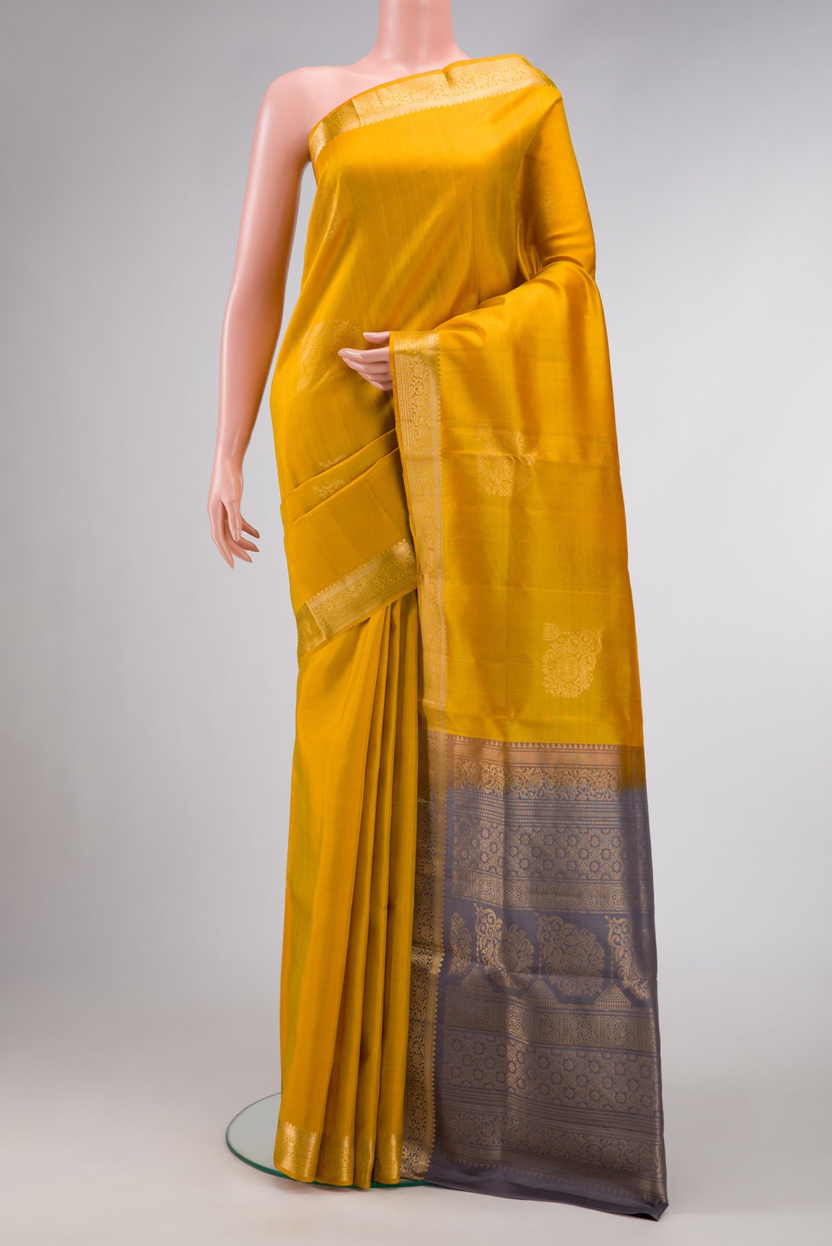 Mustard Dual Tone Soft Silk Saree with Zari Butta on the body and Zari Border.  displayed on a mannequin
