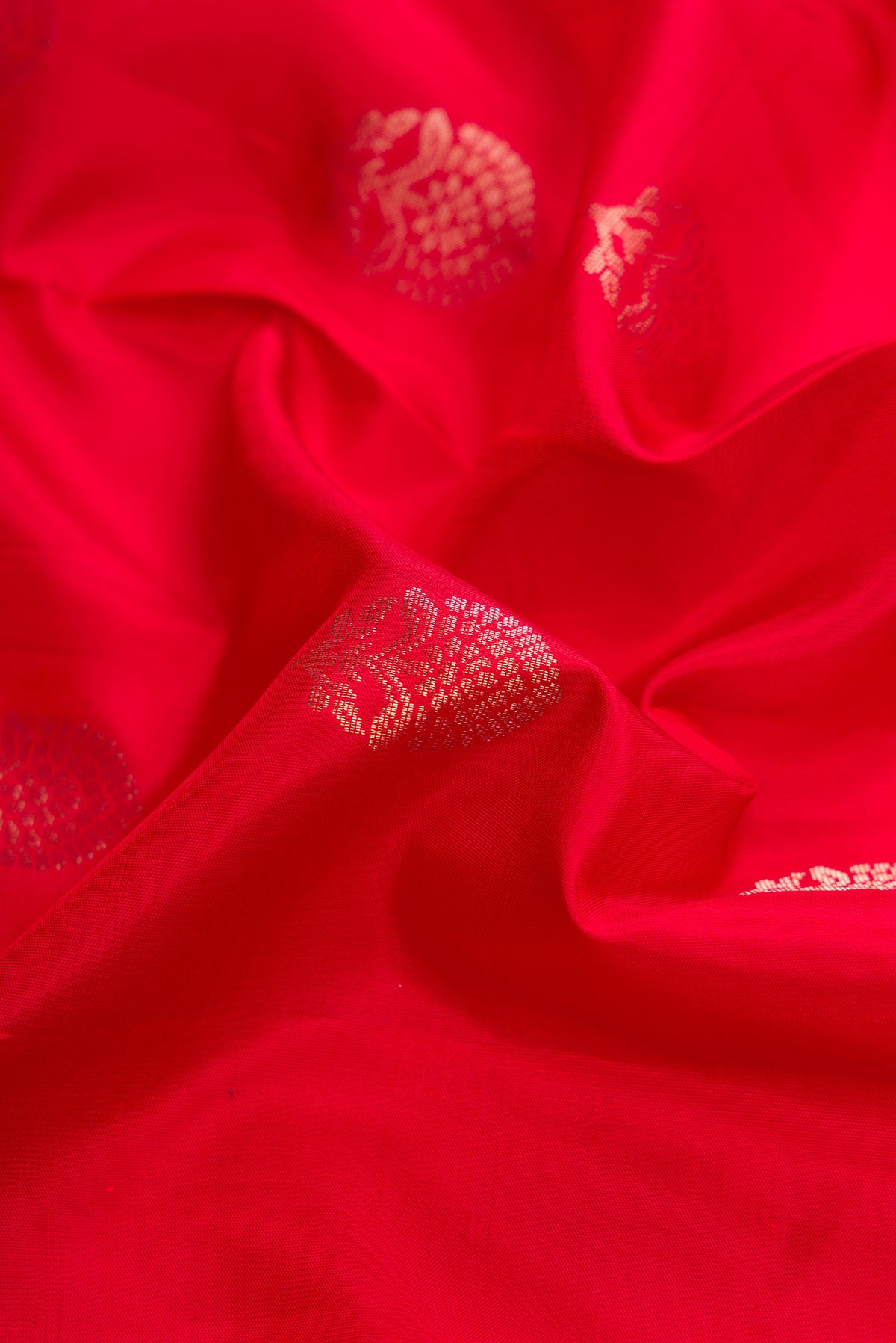Close up of Red Dual Tone Soft Silk Saree with Zari Butta on the body and Zari Border.  displaying folds