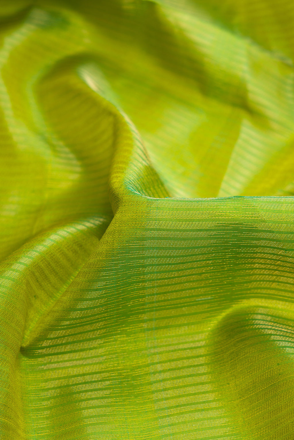 Close up of Green Dual Tone Soft Silk Saree with Zari Brocade on the body and Zari Border.  displaying folds