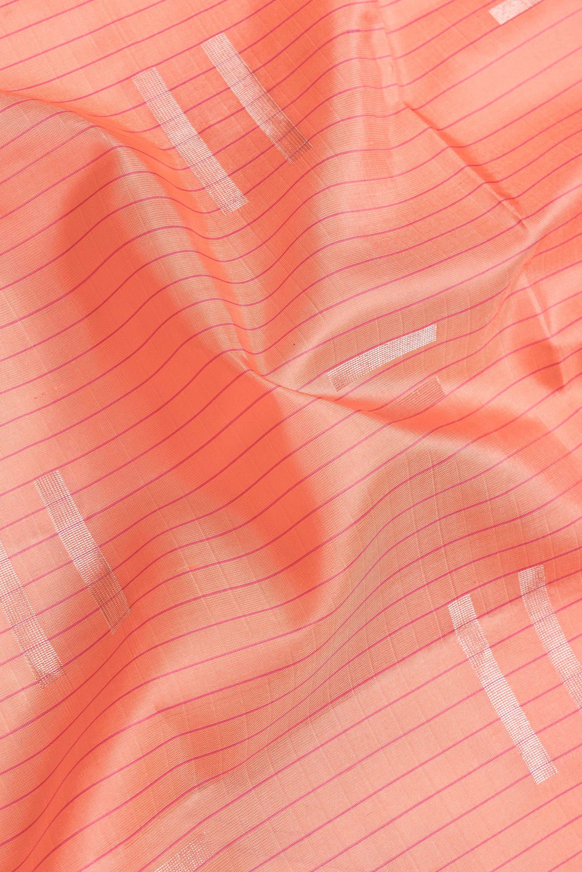 Close up of Golden Peach Dual Tone Soft Silk Saree with Zari Butta on the body and Fancy Border.  displaying folds