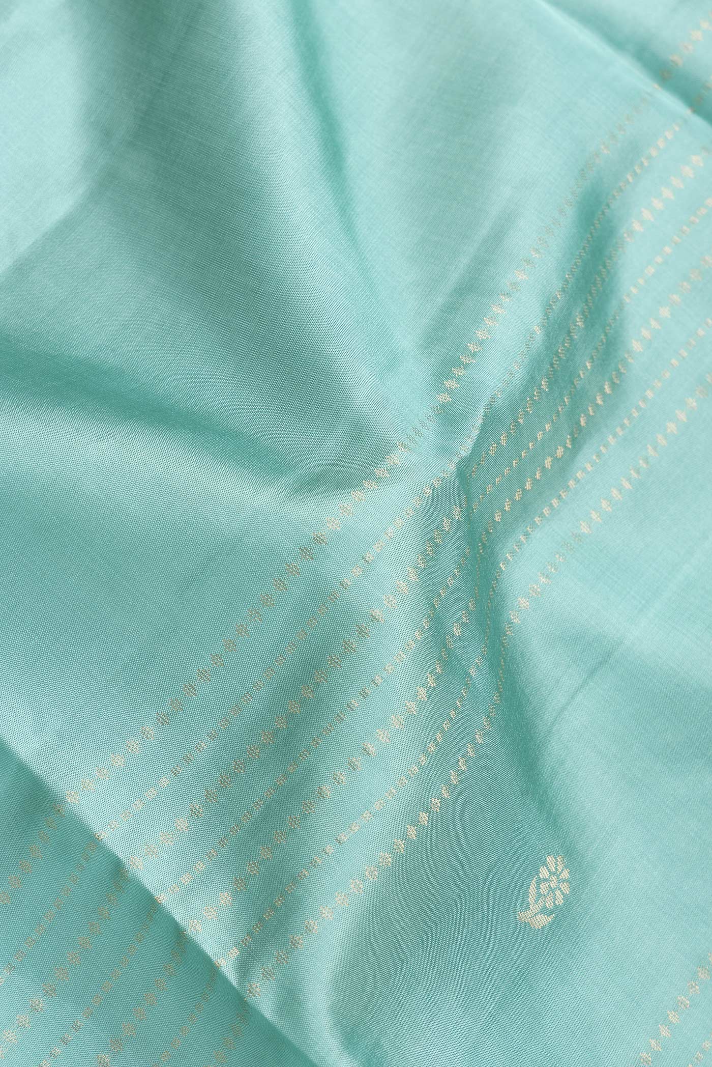 Close up of Sky Blue Dual Tone Soft Silk Saree with Zari Butta on the body and Zari Border.  displaying folds