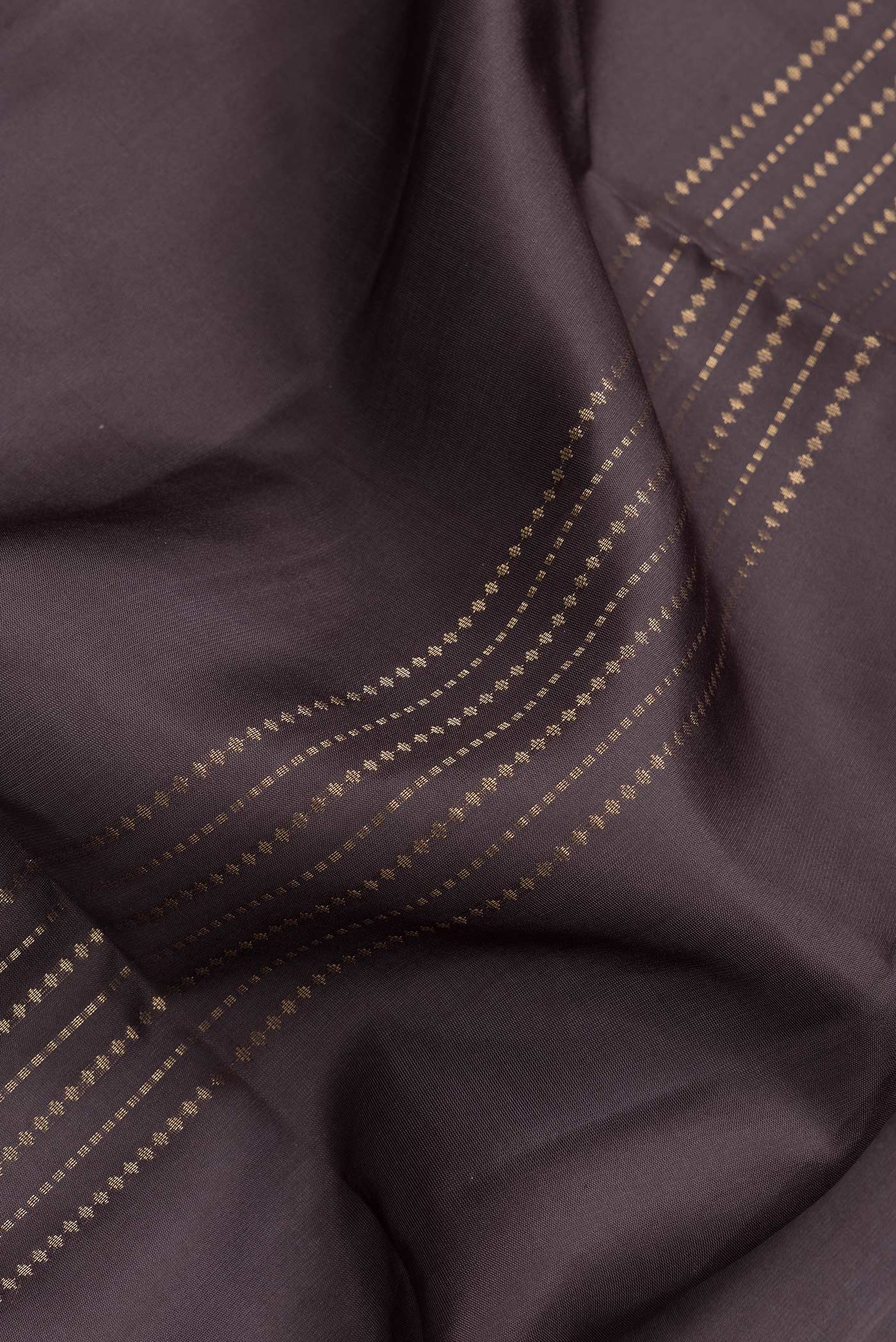 Close up of Brown Dual Tone Soft Silk Saree with Zari Butta on the body and Zari Border.  displaying folds