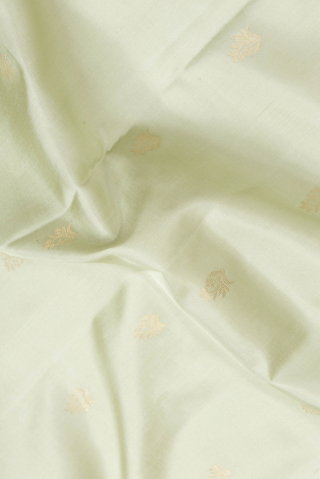 Close up of Pista Green Dual Tone Soft Silk Saree with Zari Butta on the body and Zari Border.  displaying folds