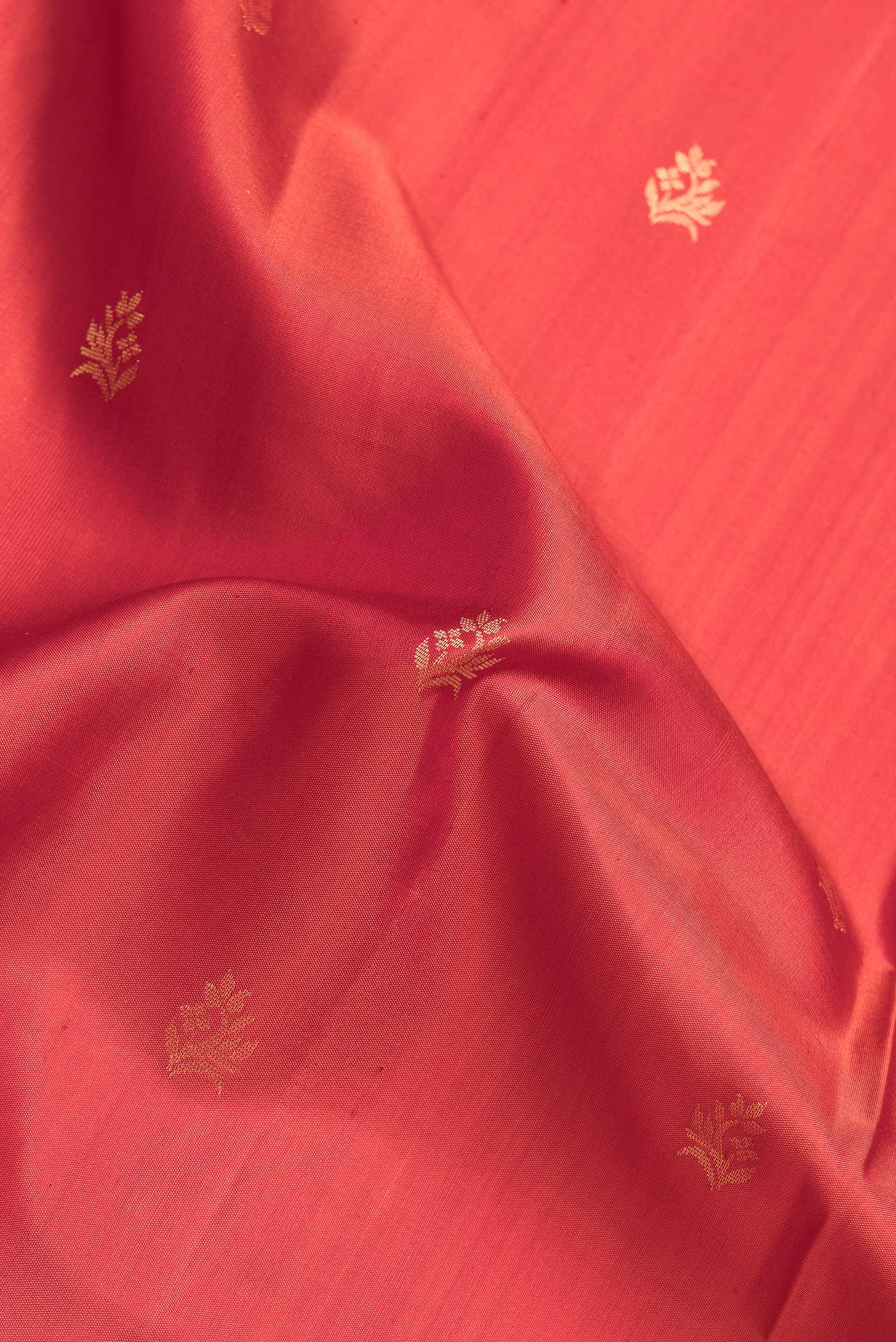 Close up of Brick Orange Dual Tone Soft Silk Saree with Zari Butta on the body and Zari Border.  displaying folds