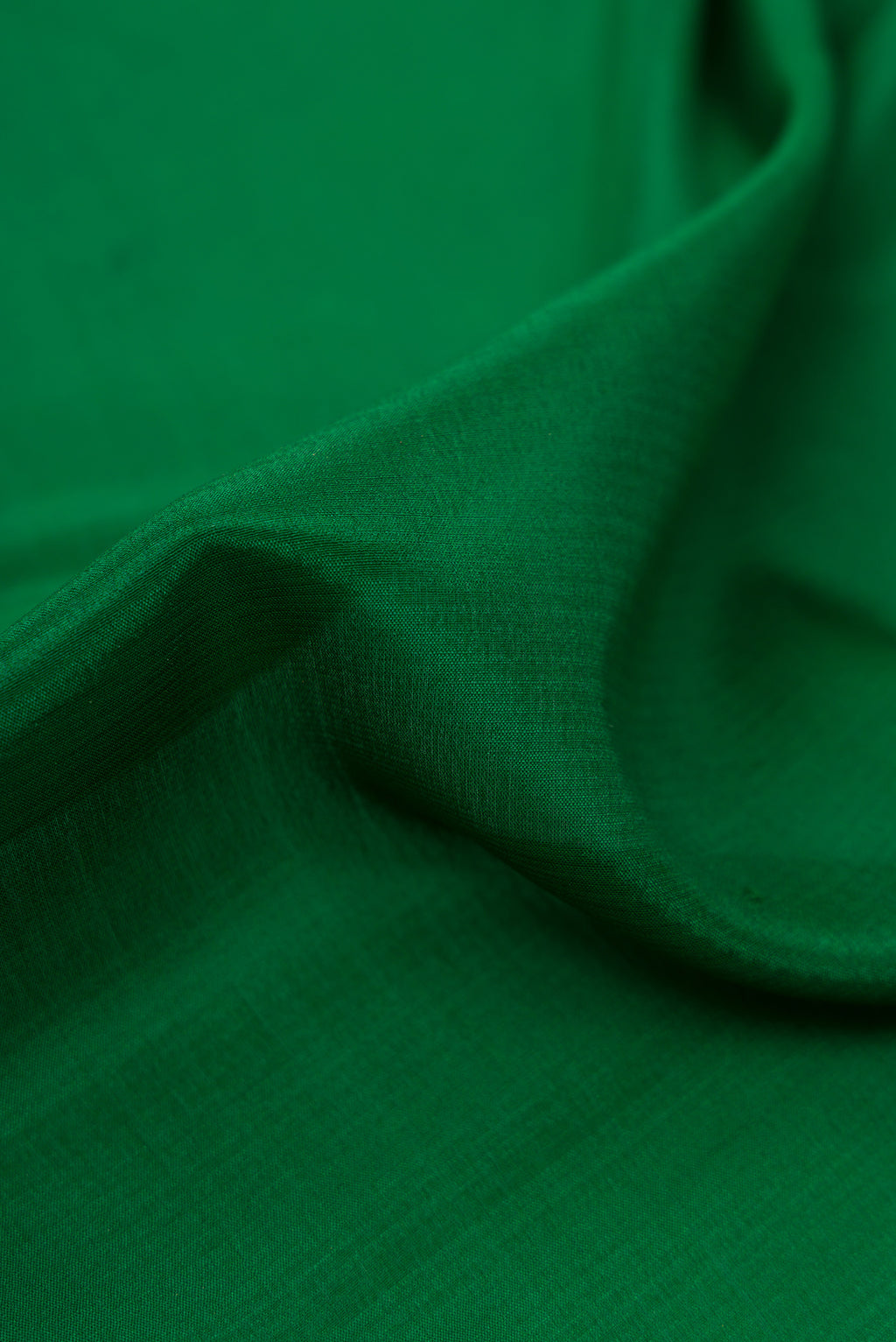 Close up of Bottle Green Mysore Crepe Saree with Plain Body and Zari Border.  displaying folds