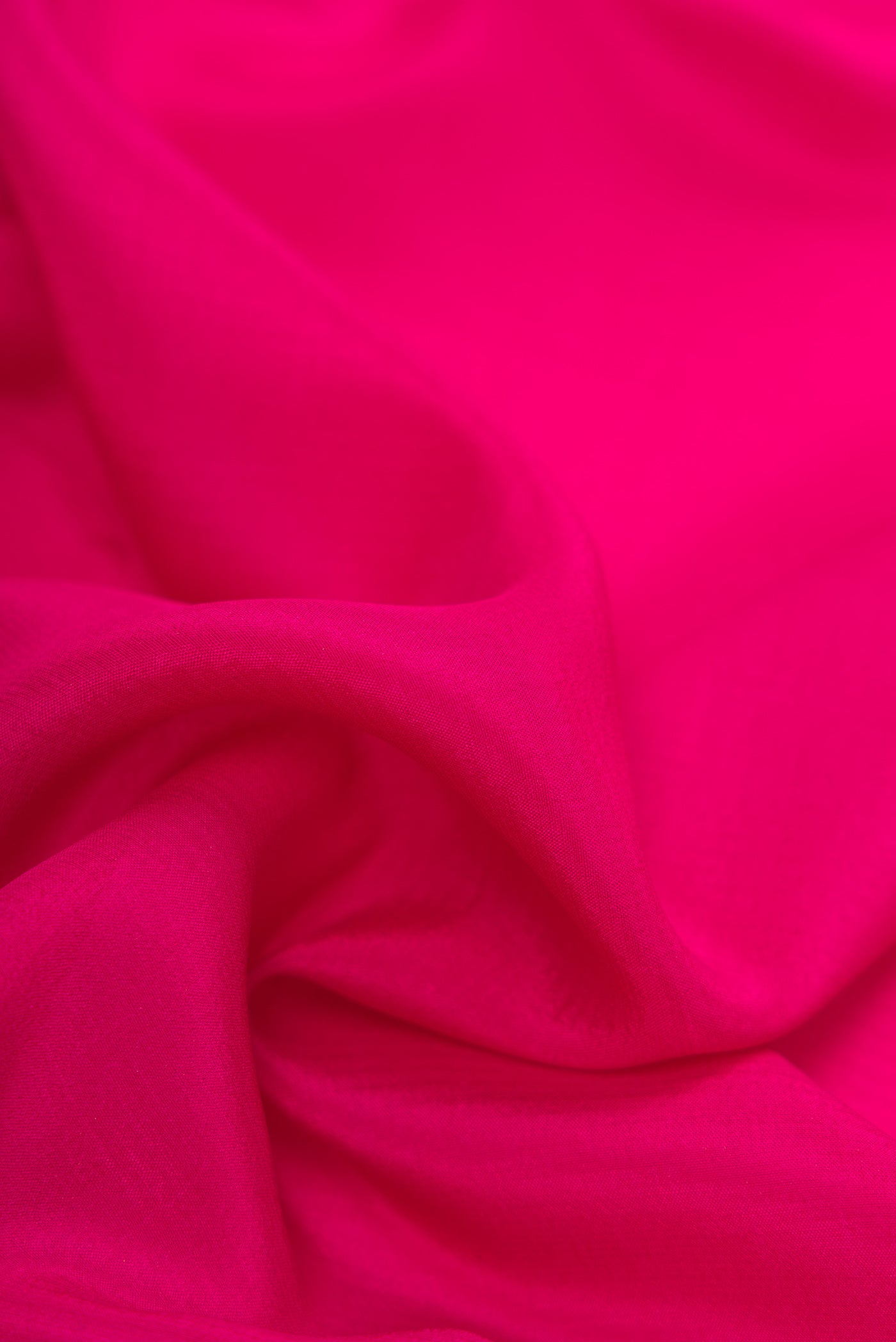 Close up of Dark Pink Mysore Crepe Saree with Plain Body and Zari Border.  displaying folds