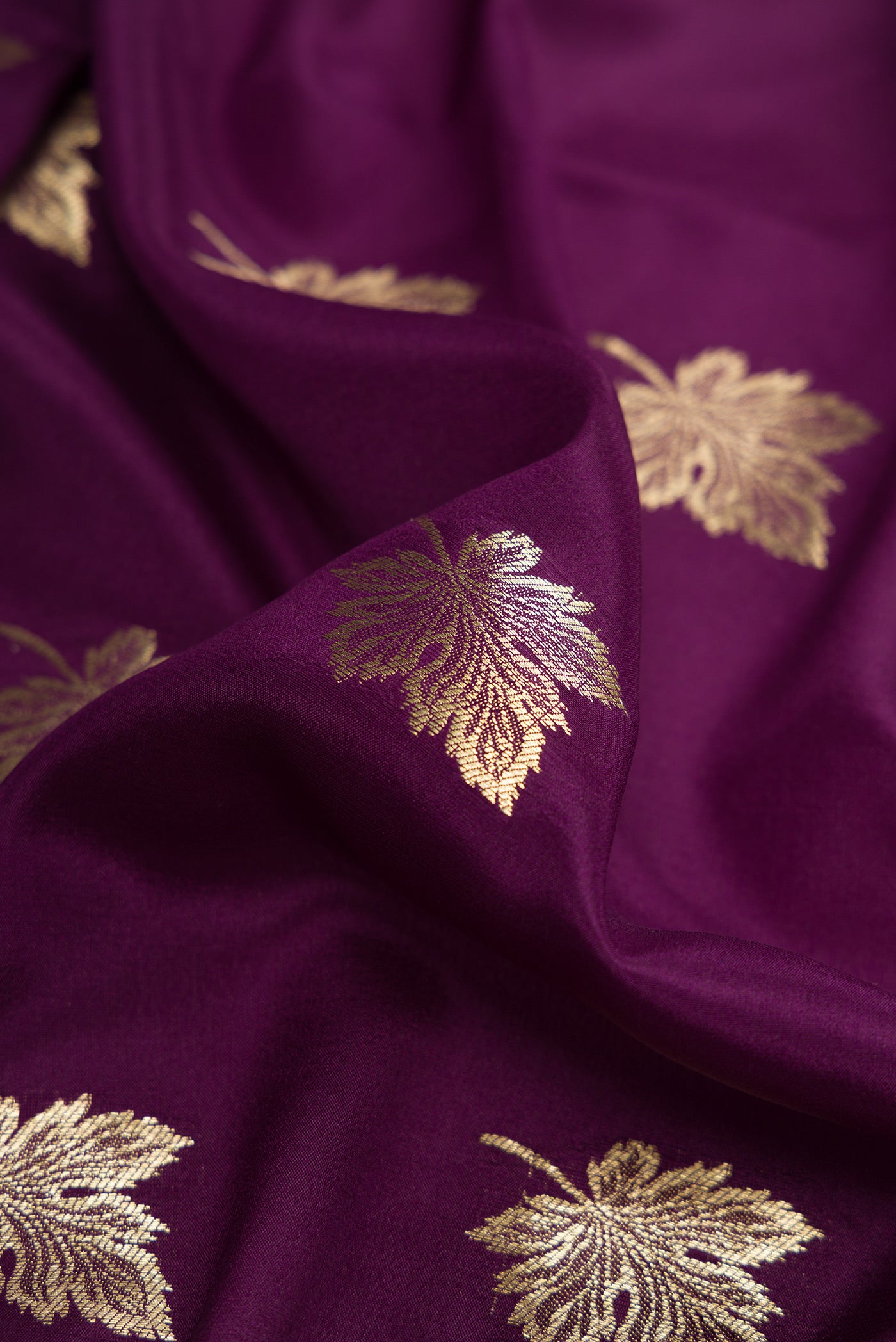 Close up of Burgundy Dual Tone Mysore Silk Saree with Zari Butta on the body and Zari Border.  displaying folds