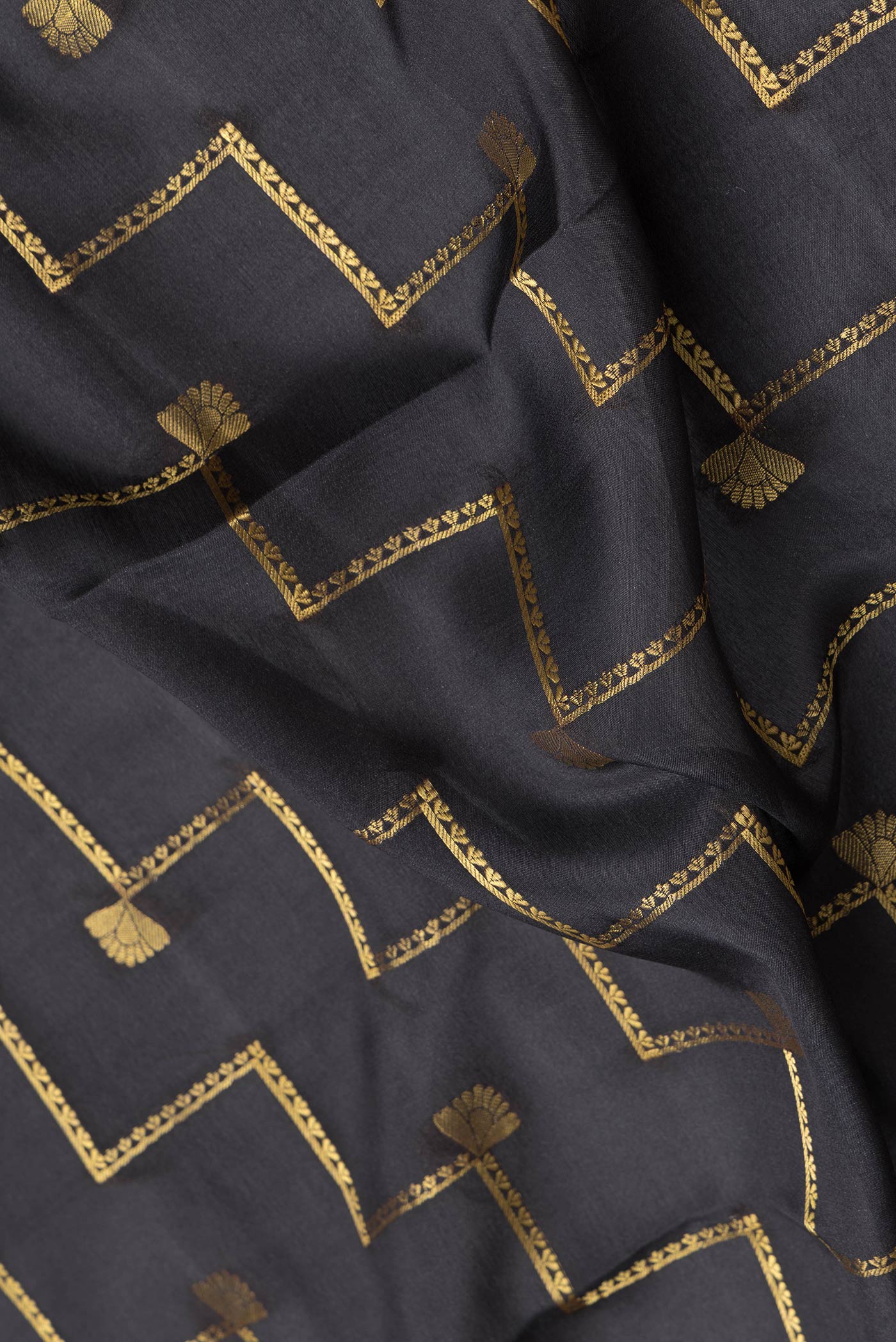 Close up of Black Dual Tone Mysore Silk Saree with Zari Butta on the body and Fancy Border.  displaying folds