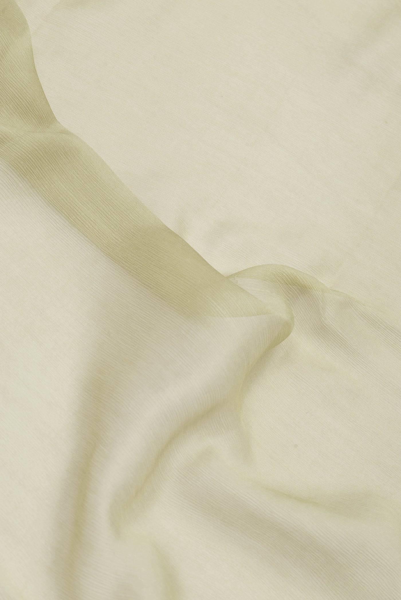 Close up of Pista Green Mysore Chiffon Saree with Plain Body and Zari Border.  displaying folds