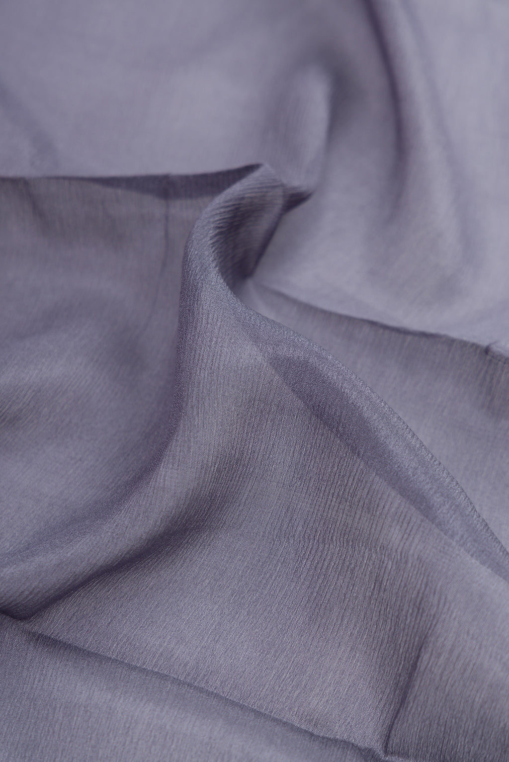 Close up of Grey Georgette Saree with Plain Body and Zari Border.  displaying folds