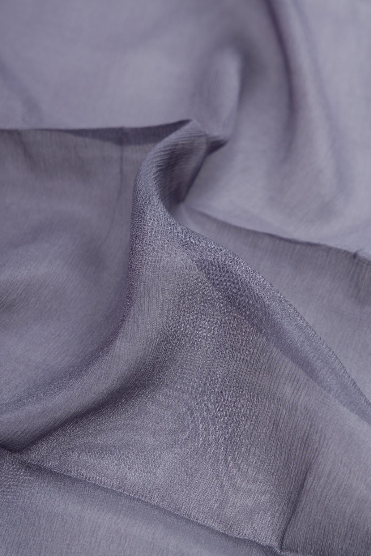 Close up of Grey Georgette Saree with Plain Body and Zari Border.  displaying folds