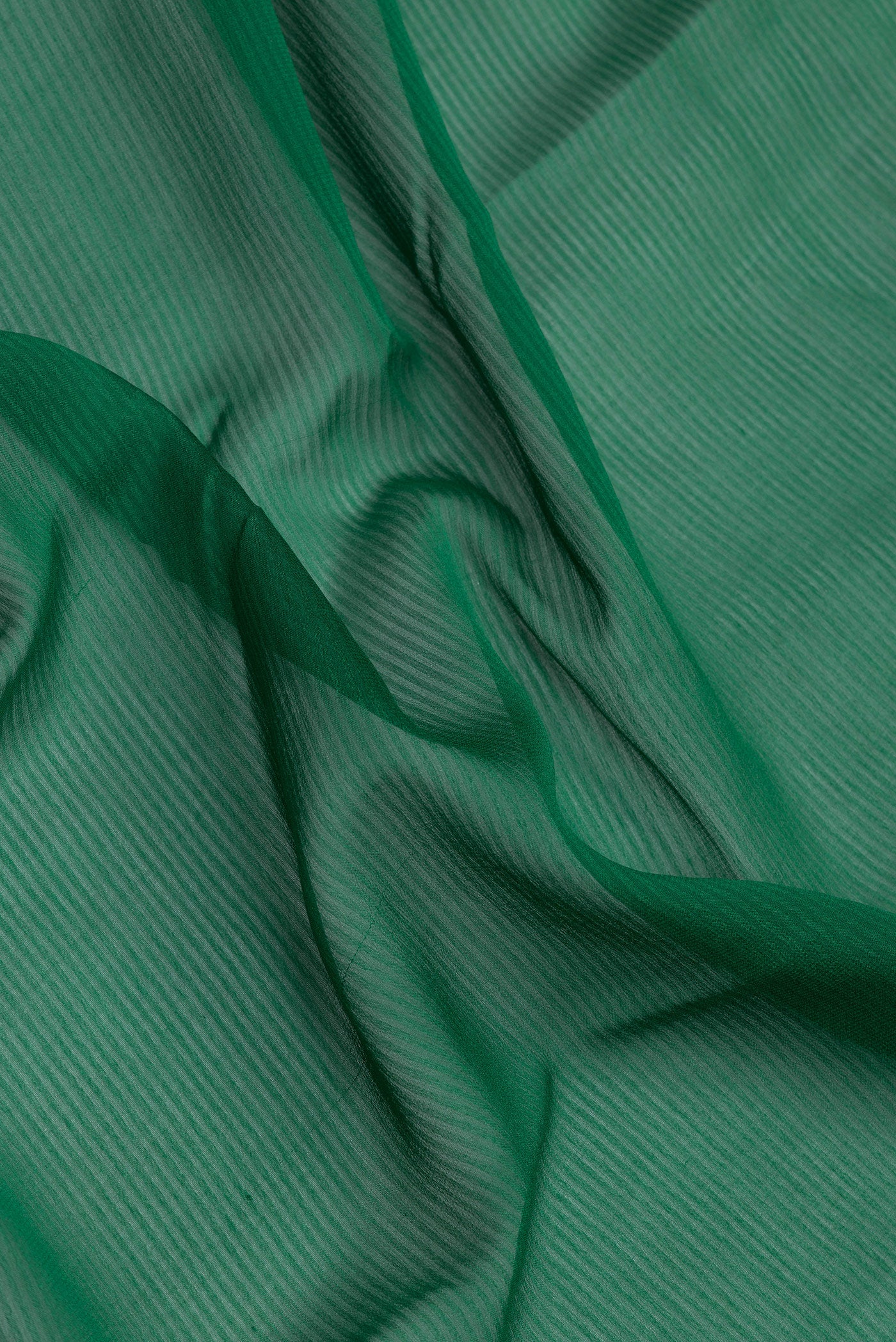 Close up of Green Georgette Saree with Stripes on the body and Zari Border.  displaying folds