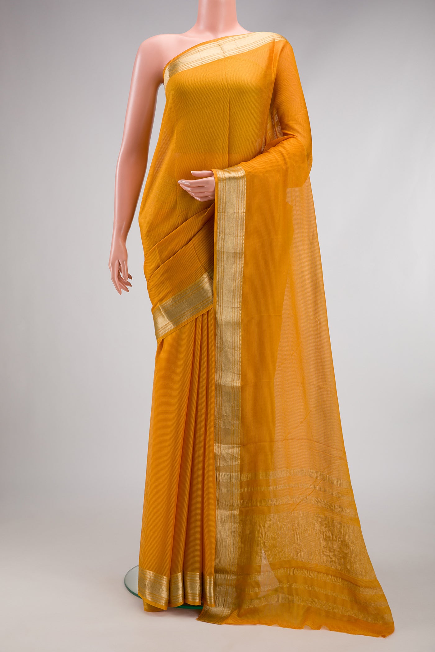 Mustard Mysore Georgette Saree with Stripes on the body and Zari Border.  displayed on a mannequin