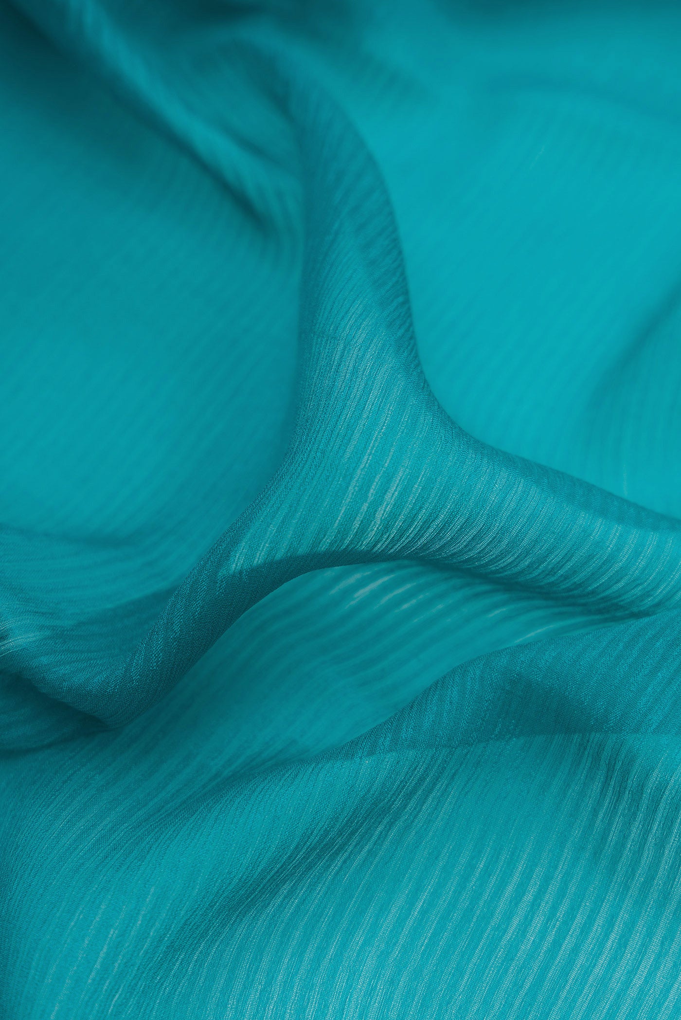 Close up of Peacock Blue Mysore Georgette Saree with Stripes on the body and Zari Border.  displaying folds