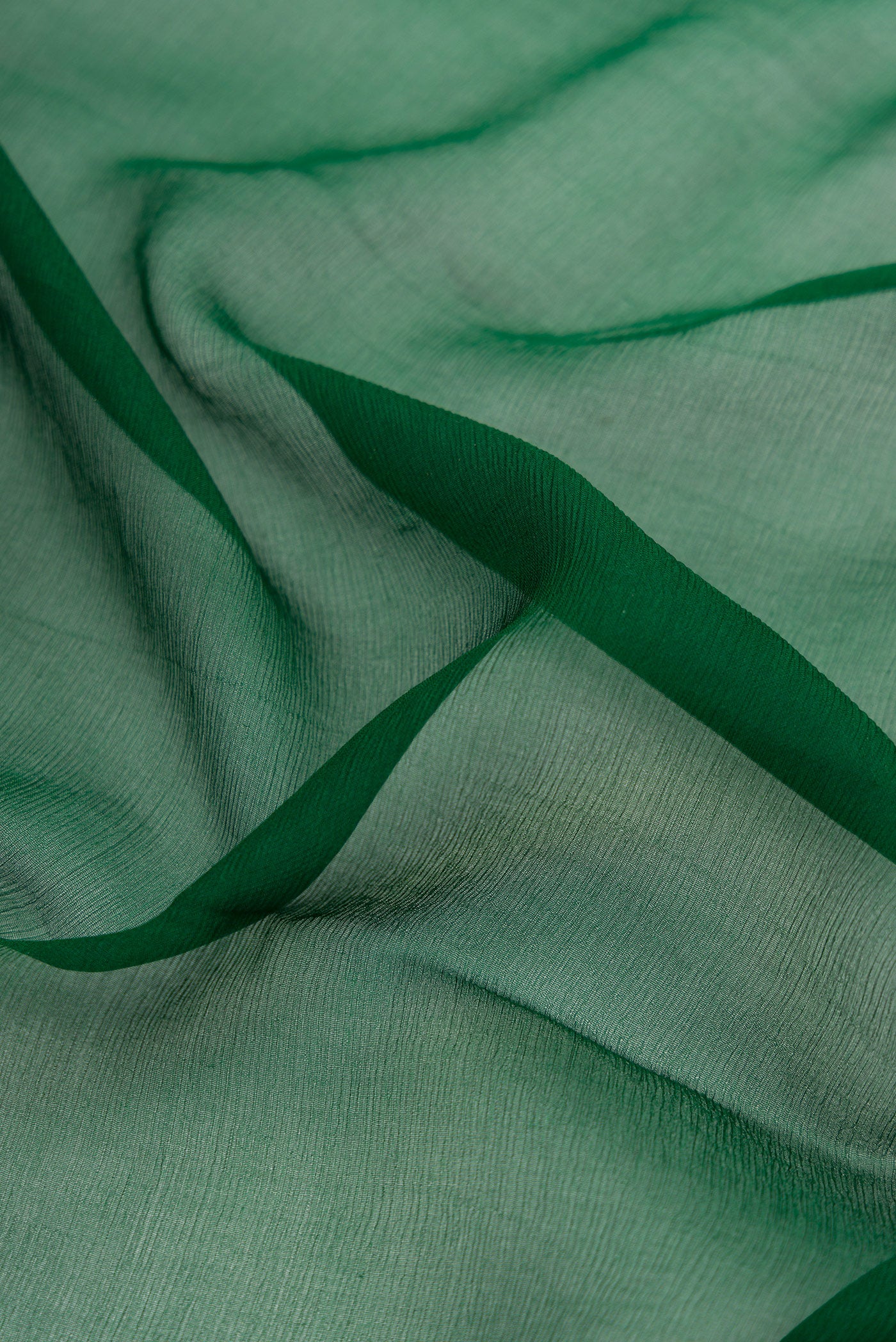 Close up of Bottle Green Mysore Chiffon Saree with Plain Body and Fancy Border.  displaying folds