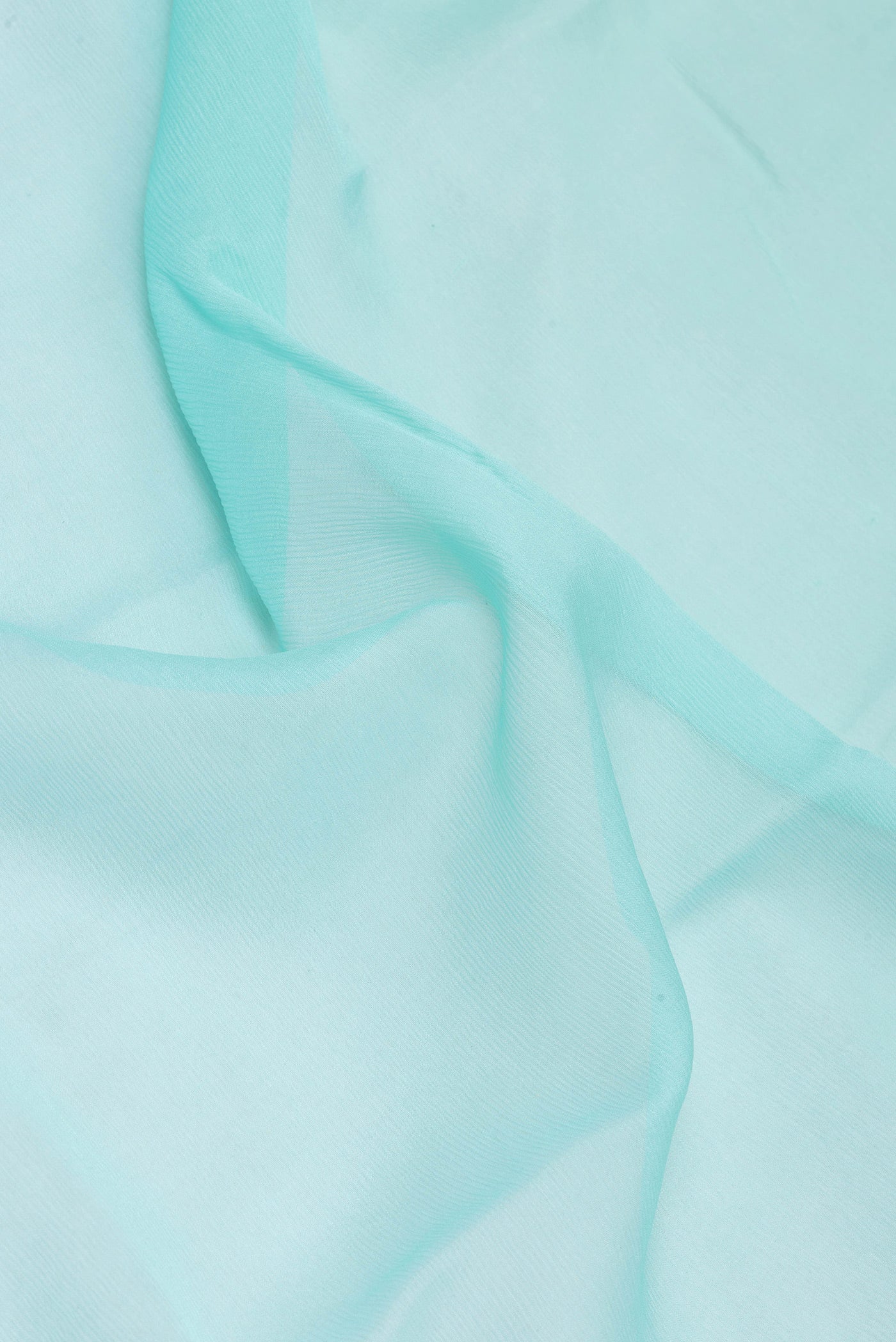 Close up of Sky Blue Mysore Chiffon Saree with Plain Body and Zari Border.  displaying folds