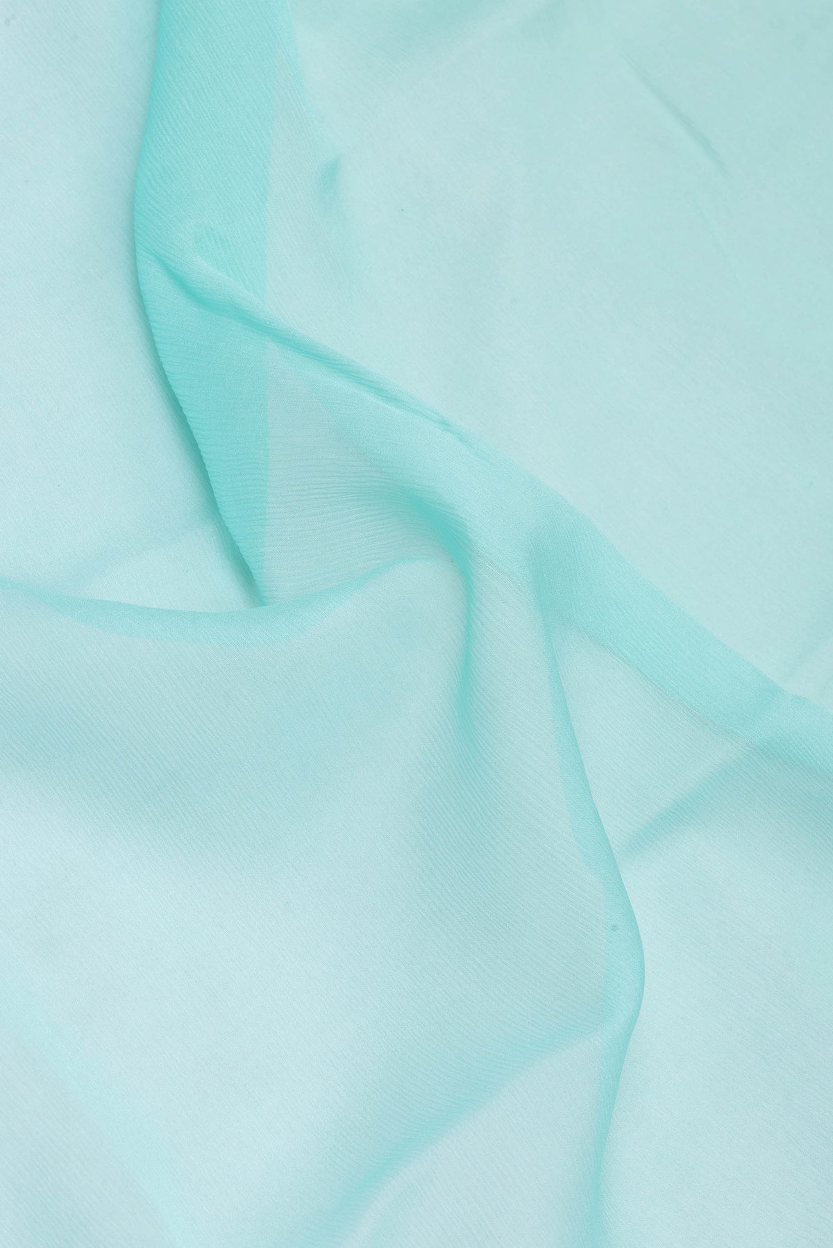 Close up of Sky Blue Mysore Chiffon Saree with Plain Body and Zari Border.  displaying folds