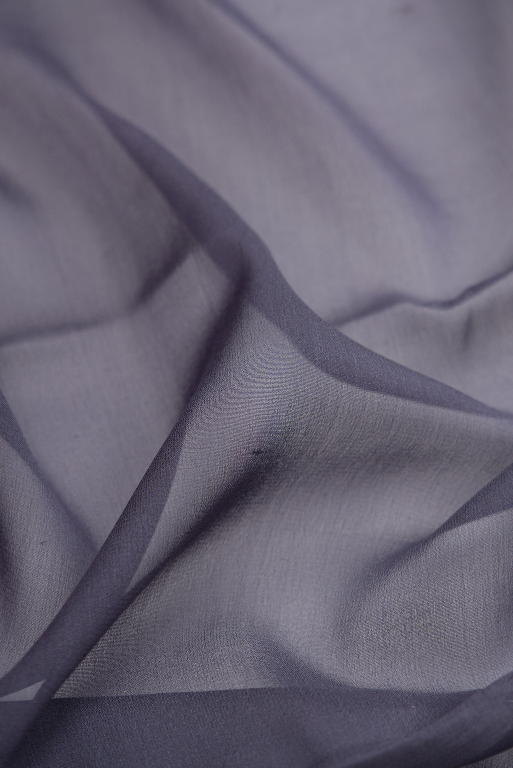 Close up of Grey Mysore Georgette Saree with Plain Body and Zari Border.  displaying folds